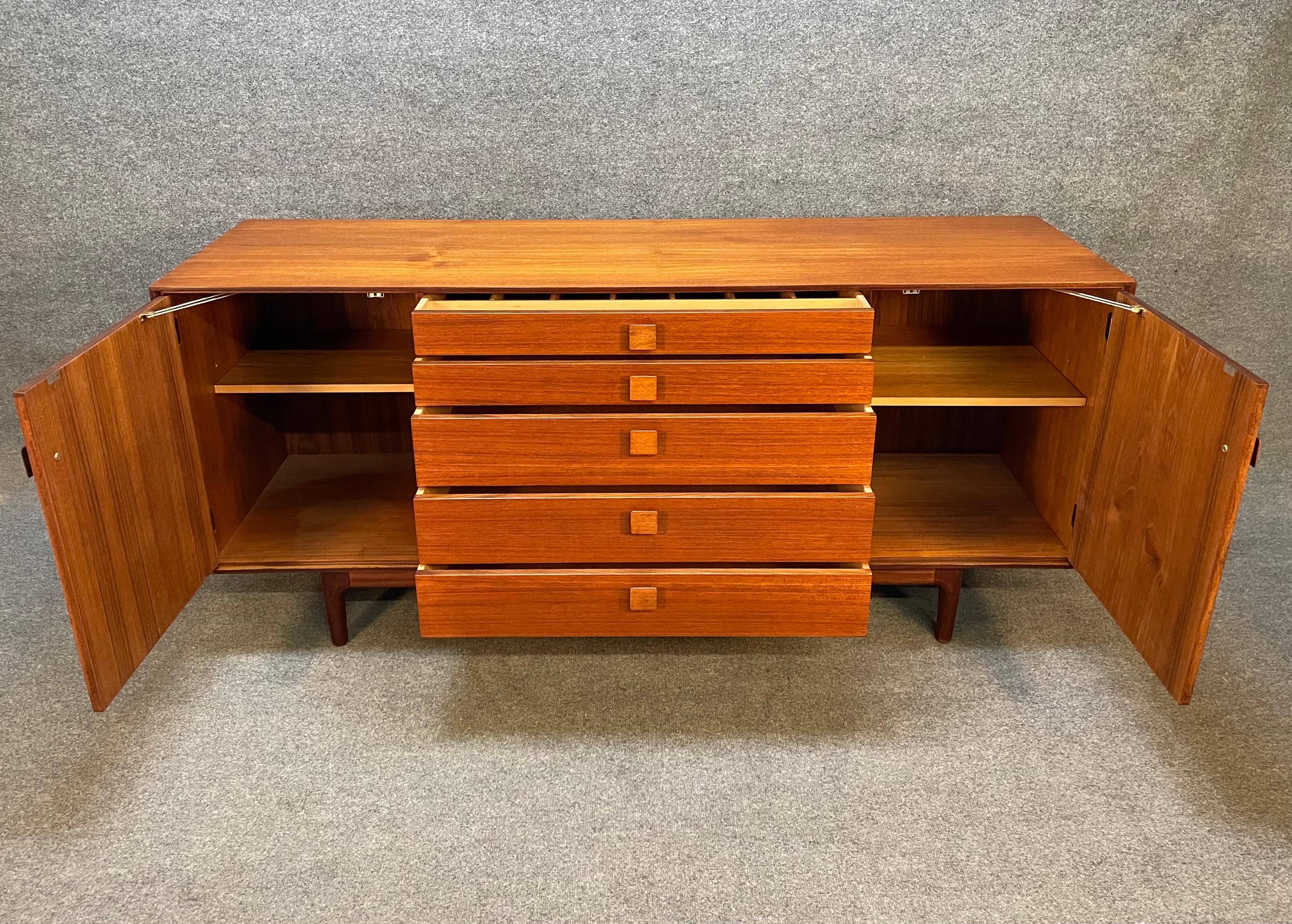 Here is a beautiful and rare British compact sideboard in teak designed by Ib Kofod Larsen and manufactured by G Plan in UK in the 1960's. This lovely credenza, recently imported from the UK to California before its refinishing, features a vibrant