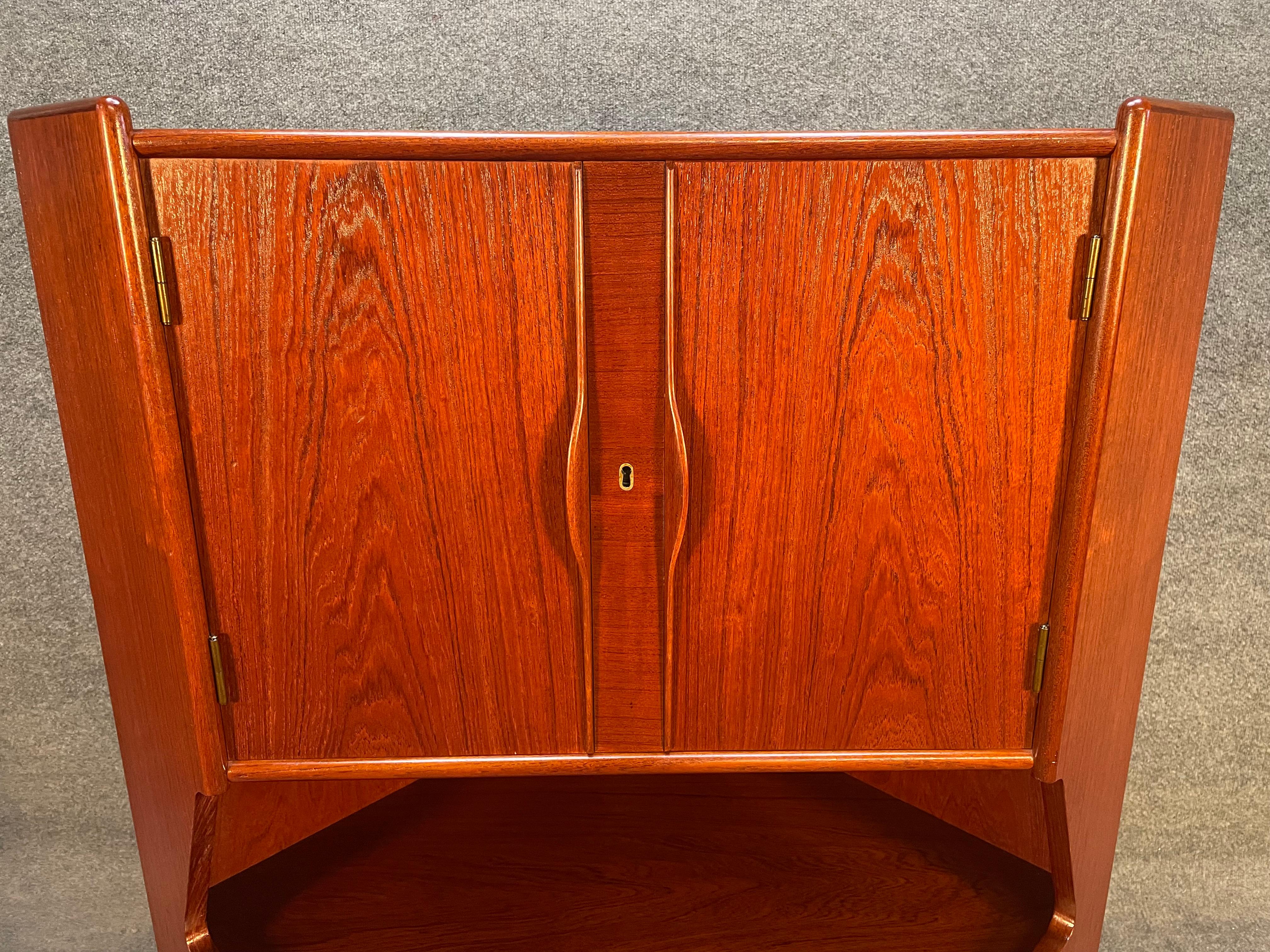 Here is a beautiful 1960's scandinavian modern teak corner cabinet recently imported from Denmark to California before its refinishing.
This lovely piece features a vibrant wood grain, a dry bar with shelving and etched mirror, three drawers and
