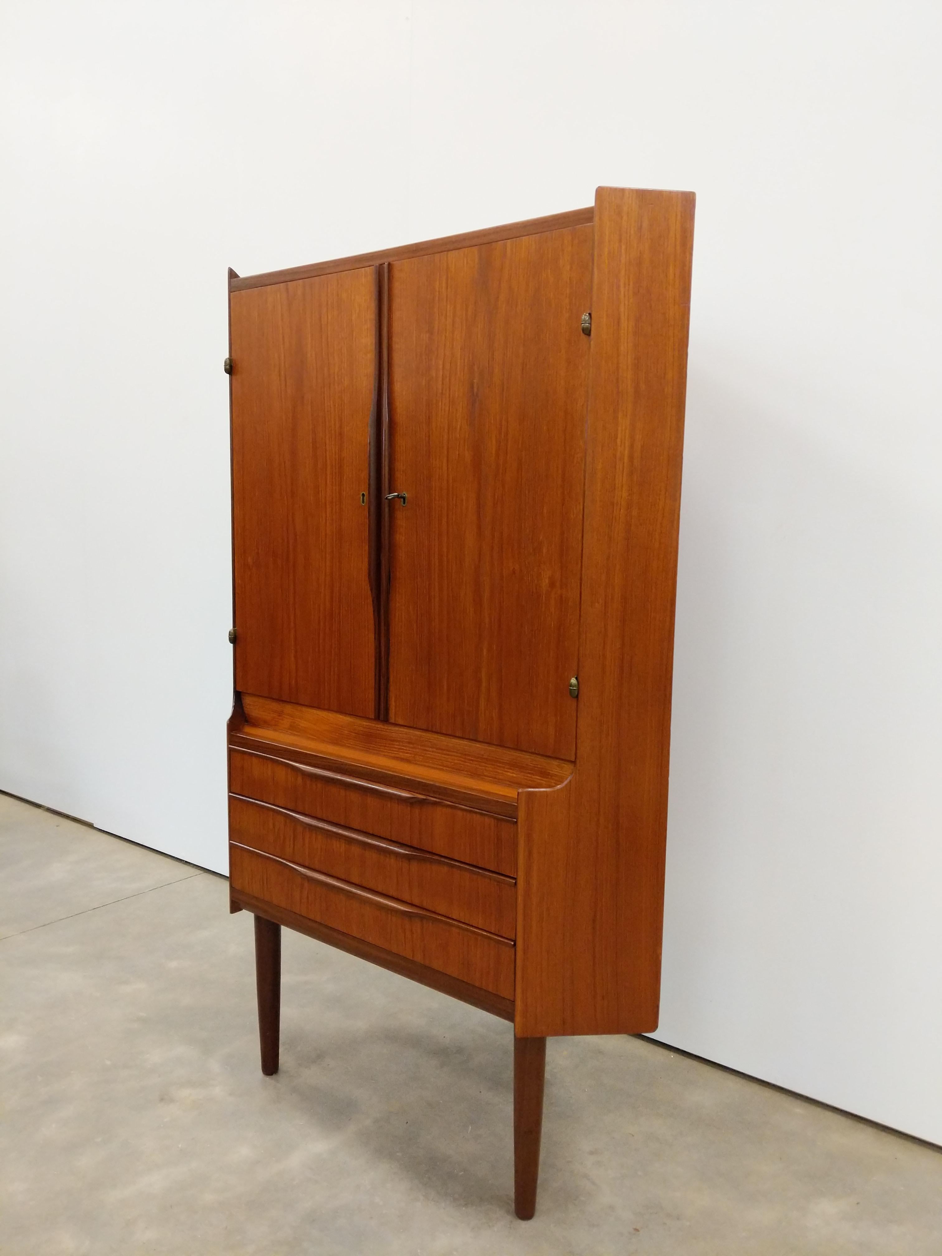 Authentischer dänischer / skandinavischer moderner Teakholz-Eckschrank aus der Mitte des Jahrhunderts.

Dieses Stück ist in ausgezeichnetem Zustand mit sehr wenigen altersbedingten Abnutzungserscheinungen (siehe Fotos).

Wenn Sie weitere
