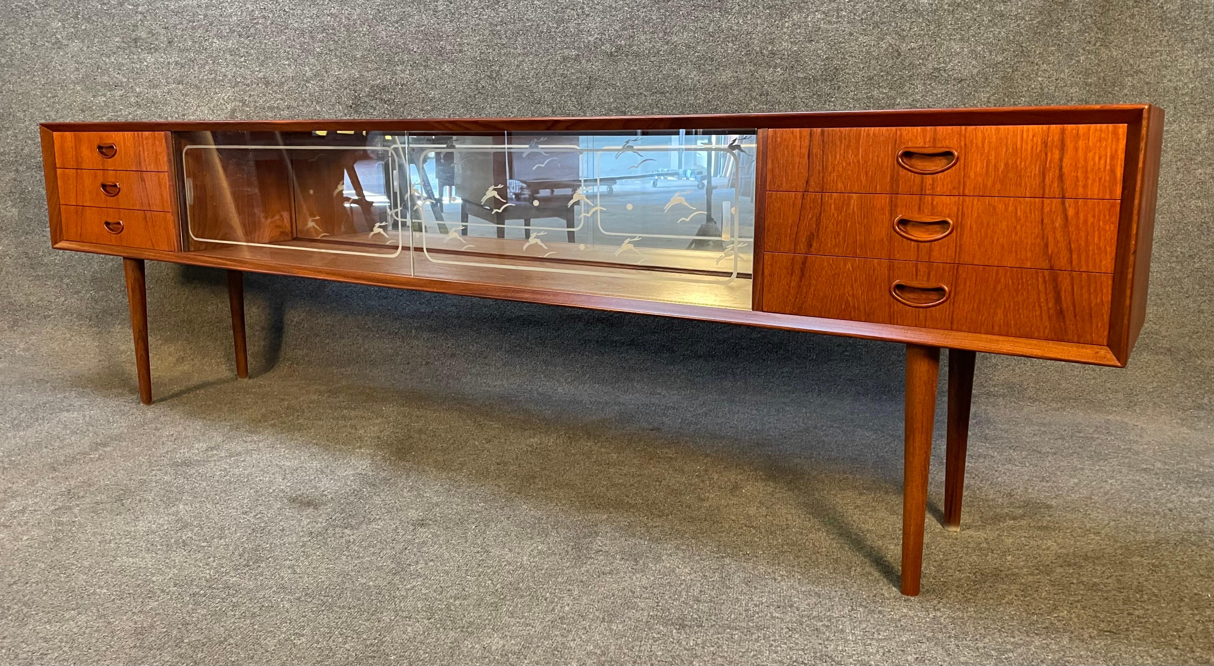 Here is a beautiful long and low 1960's Scandinavian sideboard in teak reminiscent of Peter Hvidt's design.
This credenza, recently imported from Europe to California before its refinishing, features a vibrant wood grain, two banks of three dove