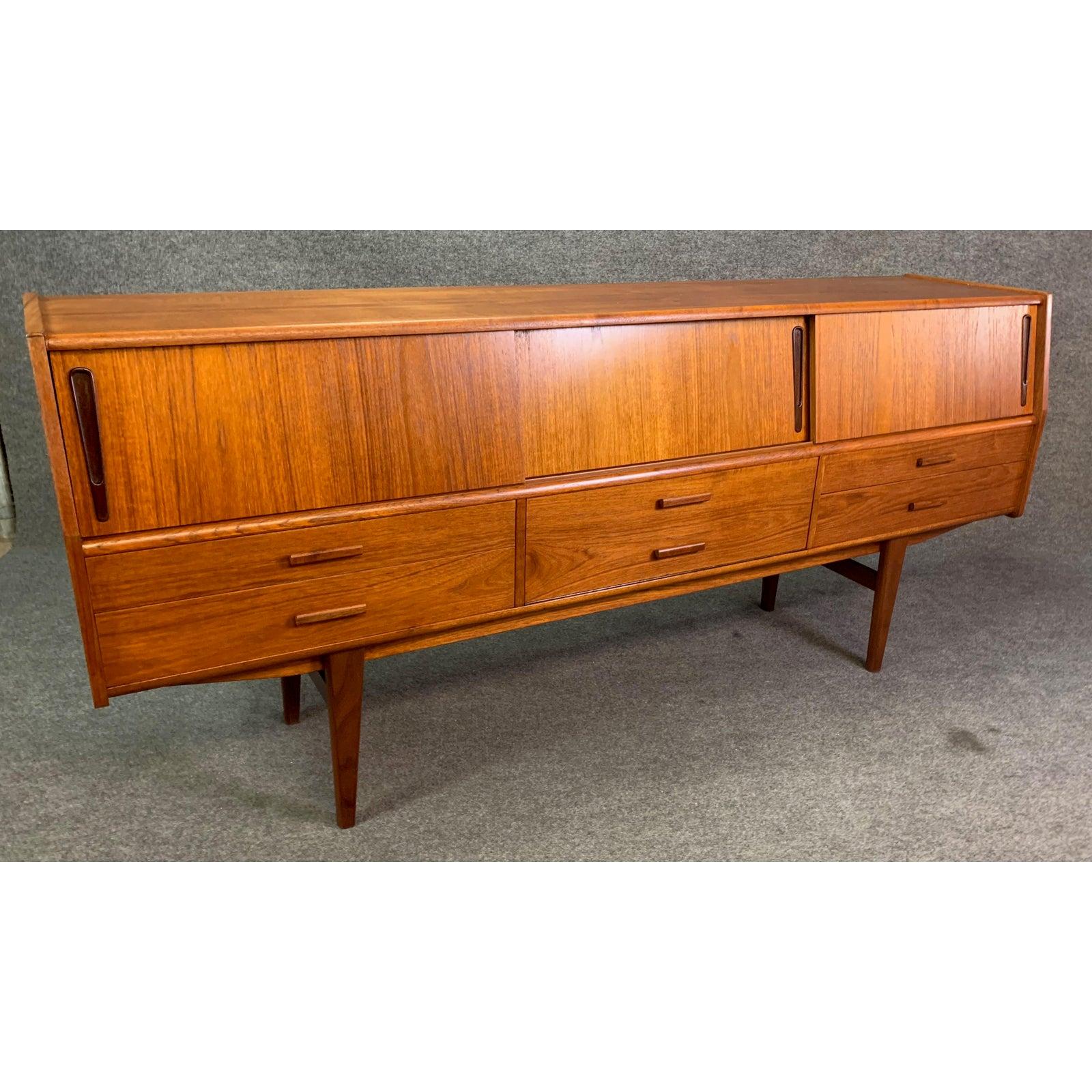 Here is an exclusive Scandinavian Modern sideboard in teak wood recently imported from Copenhagen to California before its restoration.
This special case good, with its vibrant wood grain, features an angle front, three sliding doors with storage