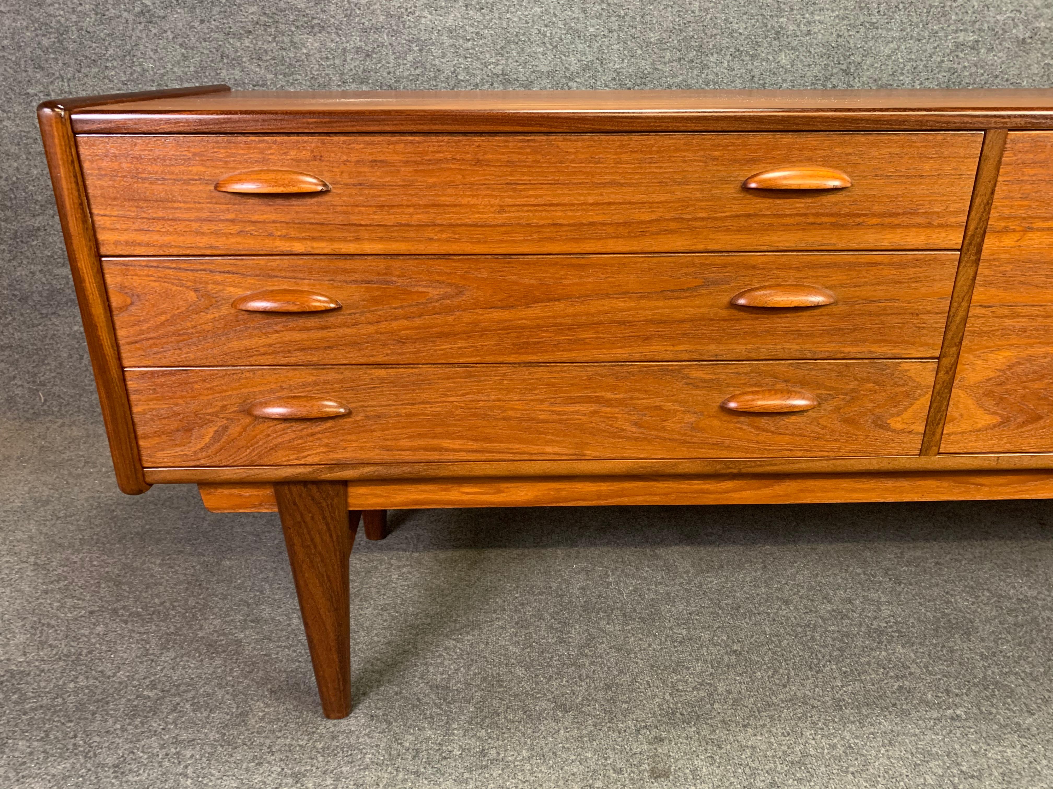 Here is a beautiful 1960s Scandinavian Modern sideboard in teak recently imported from Denmark to California before its restoration.
This case piece features a vibrant wood grain, a bank of three dove tail drawers with sculpted pulls and a drop