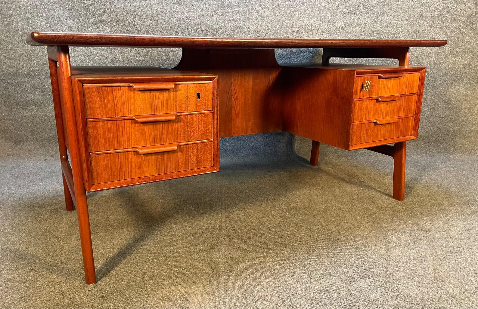 Here is the iconic Model 75 desk designed by Gunni Omann and manufactured by Omann Jun Mobelfabrik which was recently imported from Denmark to California before its restoration. This stunning 1960's Scandinavian modern desk in teak wood features a