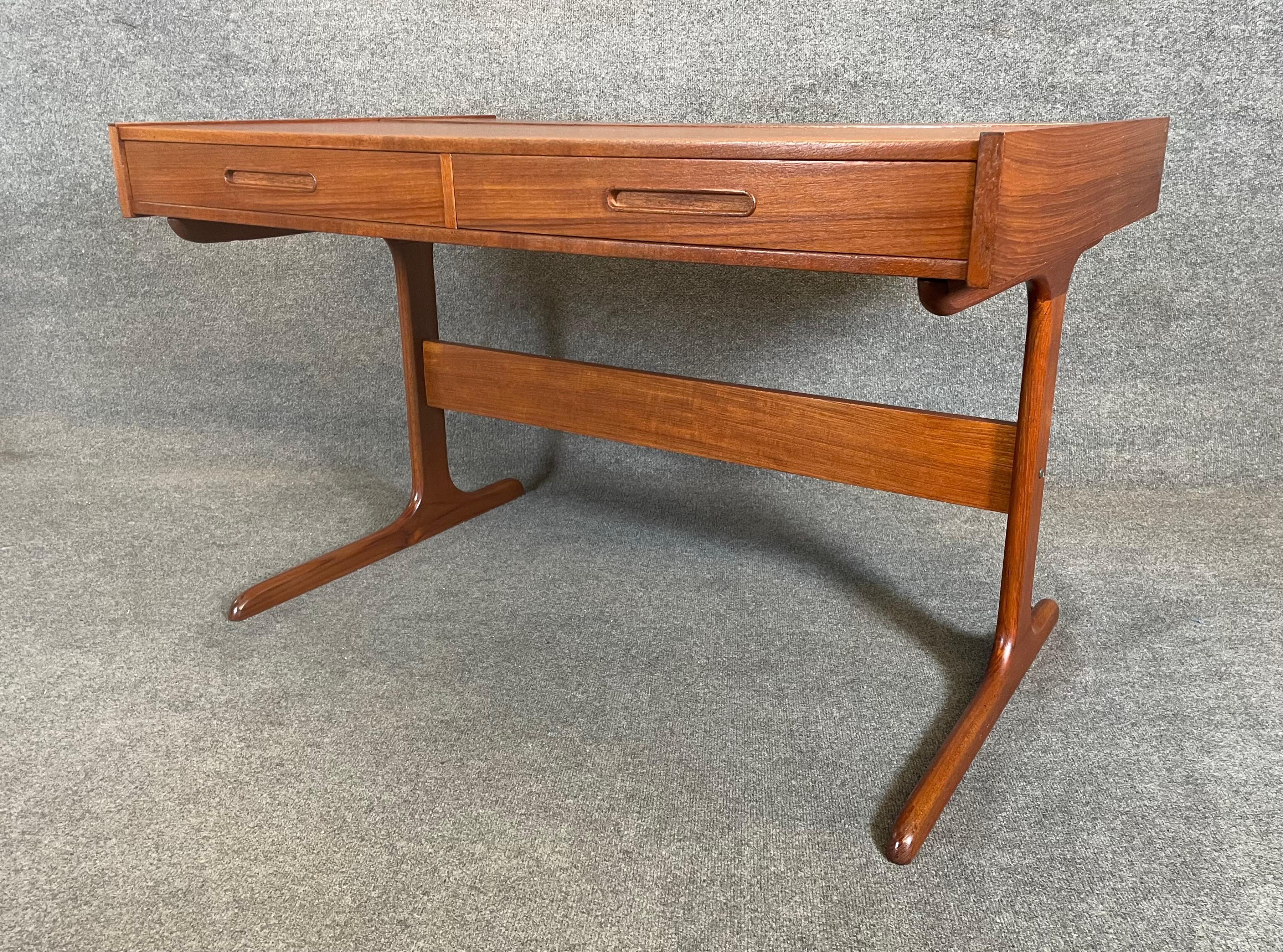 Here is a beautiful Scandinavian modern writing desk in teak manufactured in Denmark in the 1960's.
This rare piece, recently imported from Europe to California before its refinishing, features a vibrant wood grain, a large writing desk top with pop