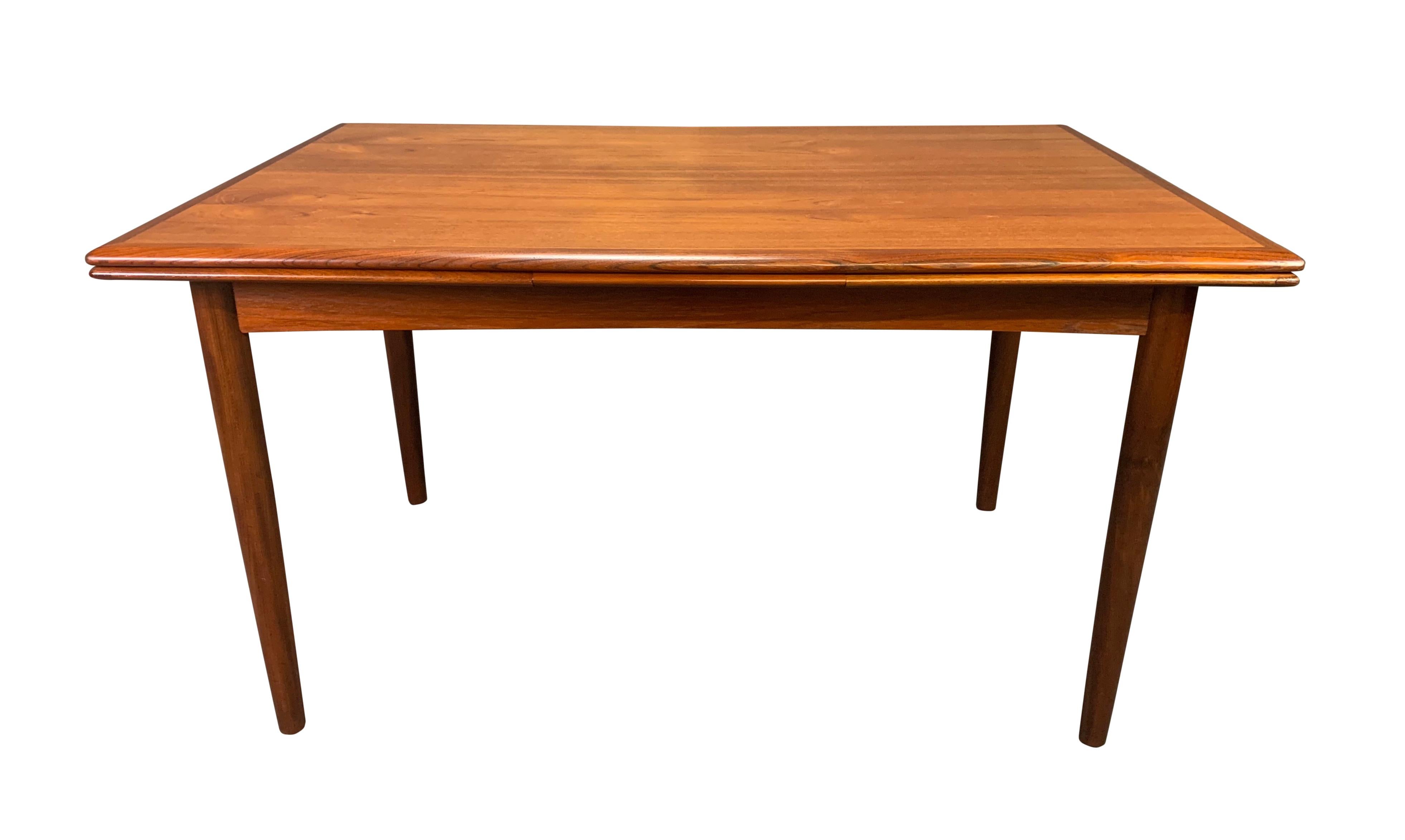 Here is a beautiful 1960s Scandinavian Modern teak dining table recently imported from Denmark to California before its restoration.
This lovely table features a vibrant wood grain, two extensions draw leaves and four solid teak tapered