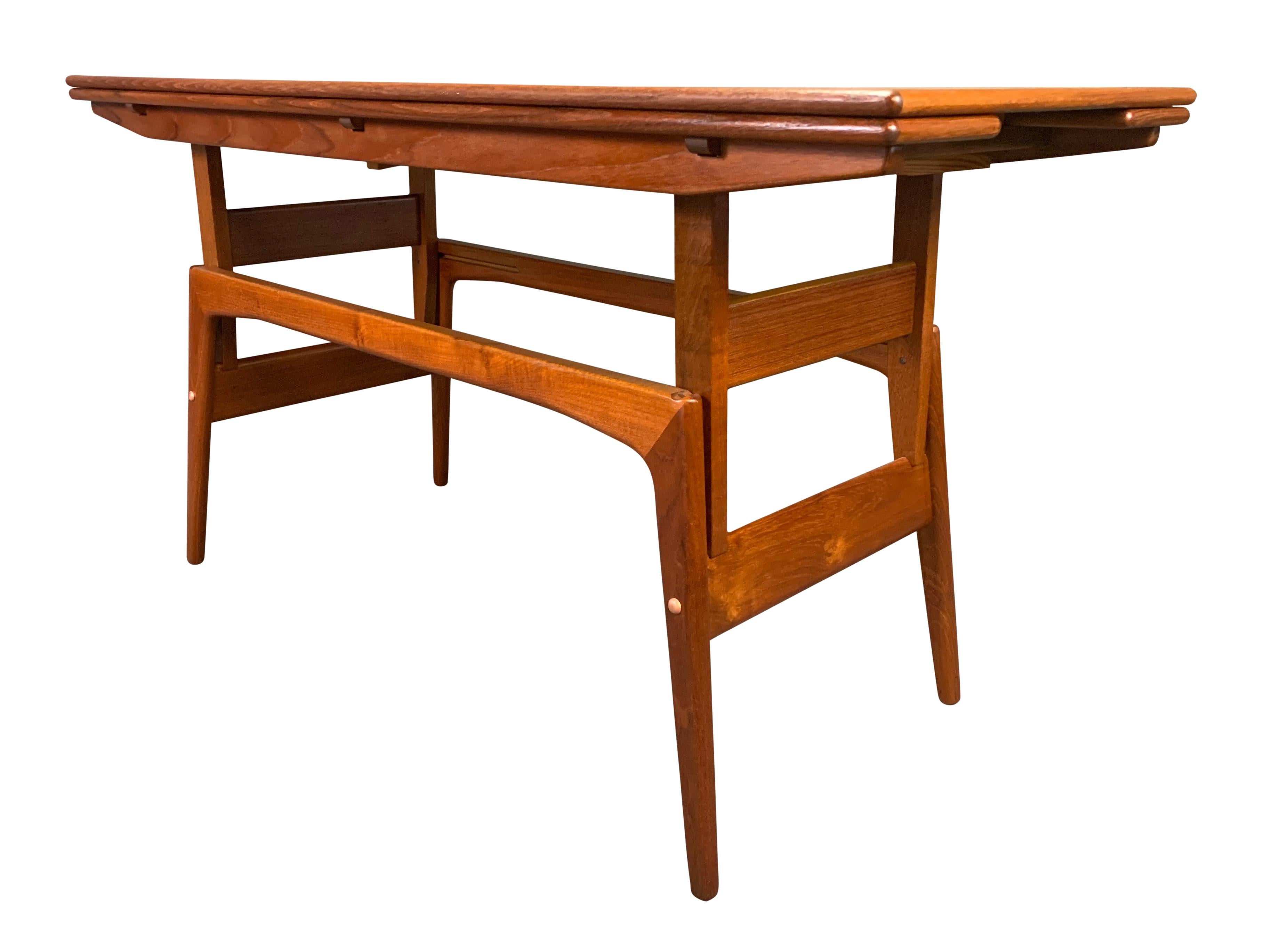 Here is a beautiful and clever 1960s Scandinavian Modern elevator table in teak attributed to designer Kai Kristiansen.
This versatile piece, recently imported from Denmark to California before its restoration, features a vibrant wood grain and