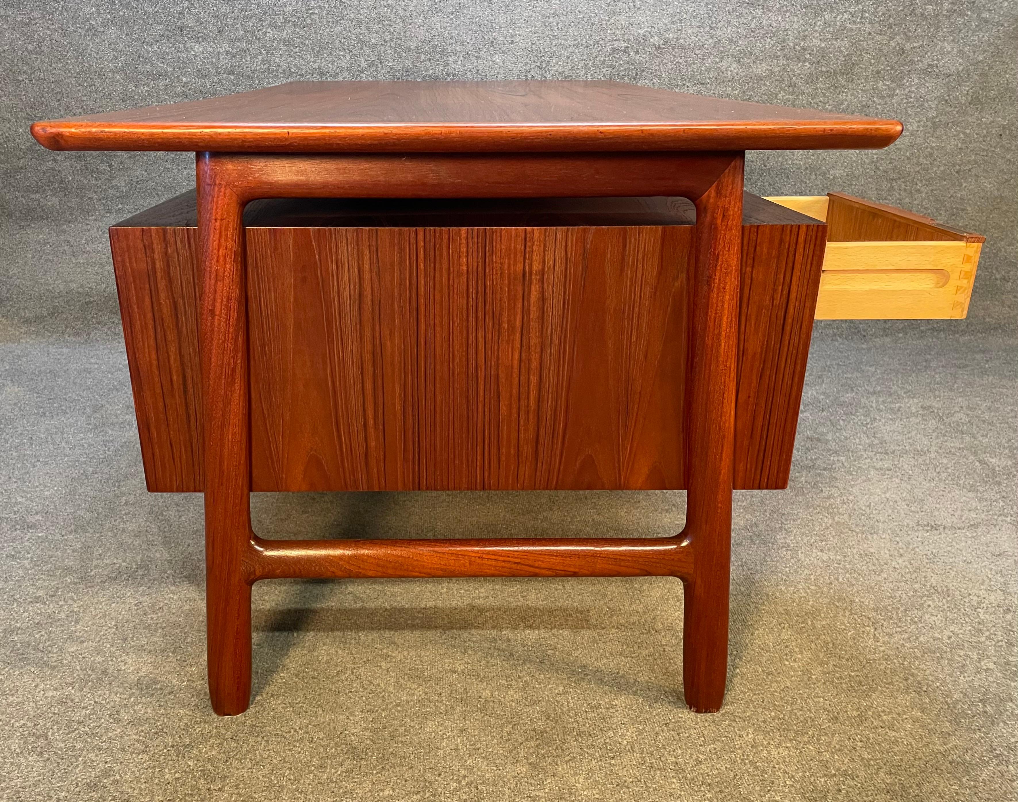 Here is the iconic Model 75 desk designed by Gunni Omann and manufactured by Omann Jun Mobelfabrik which was recently imported from Denmark to California before its restoration. This stunning 1960's Scandinavian modern desk in teak features a