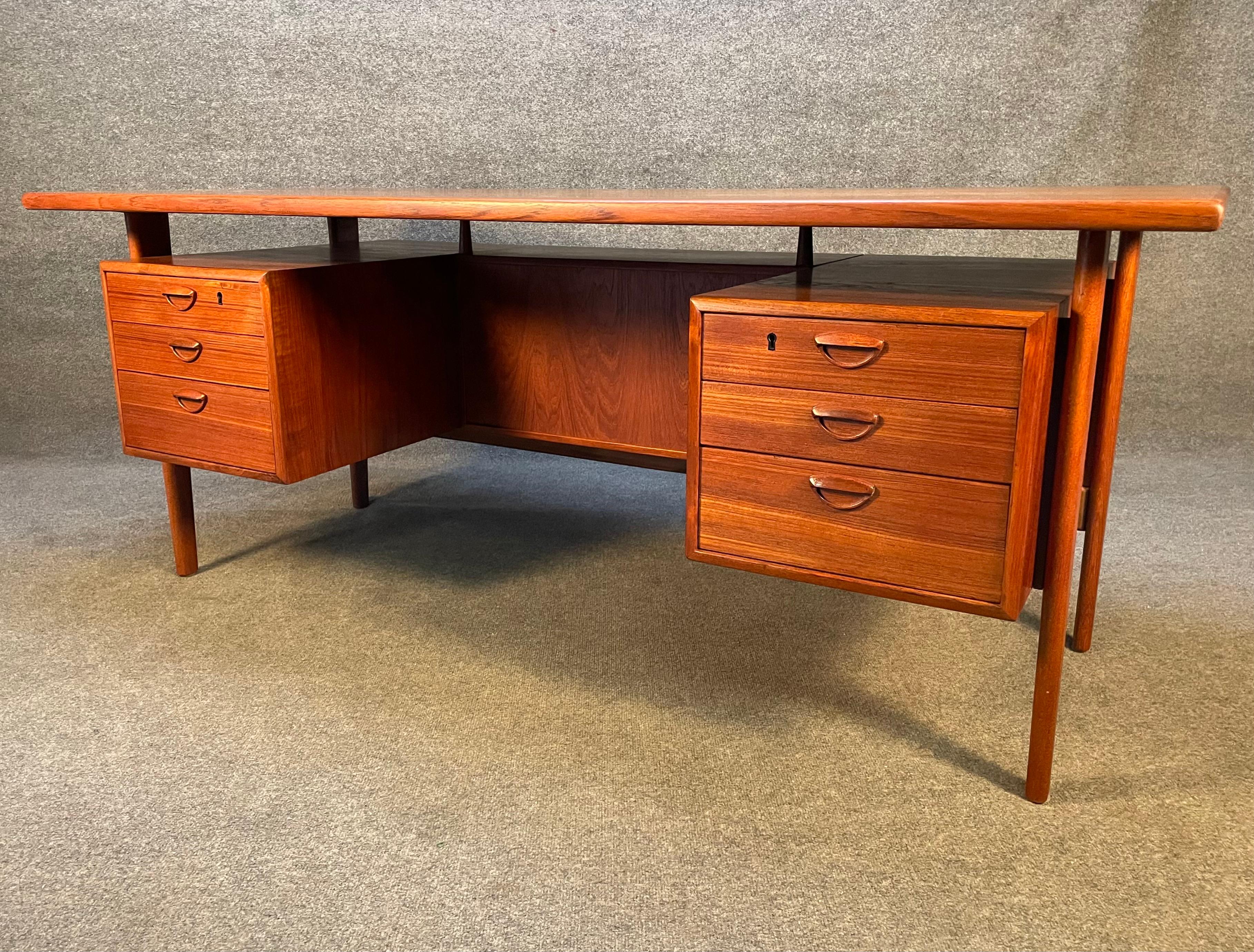 Here is the large version of the sought after Scandinavian Modern executive floating desk Model FM60 in teak designed by Kai Kristiansen and manufactured by Feldballe's Møbelfabrik in Denmark in the 1960's.
The desk features vibrant wood grain