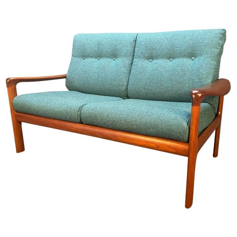 Here is a beautiful scandinavian modern 2 seaters sofa settee in teak wood manufactured by Komfort in Denmark in the late 1960's.
This comfortable loveseat, recently imported from Denmark to California before its refinishing, features a solid teak