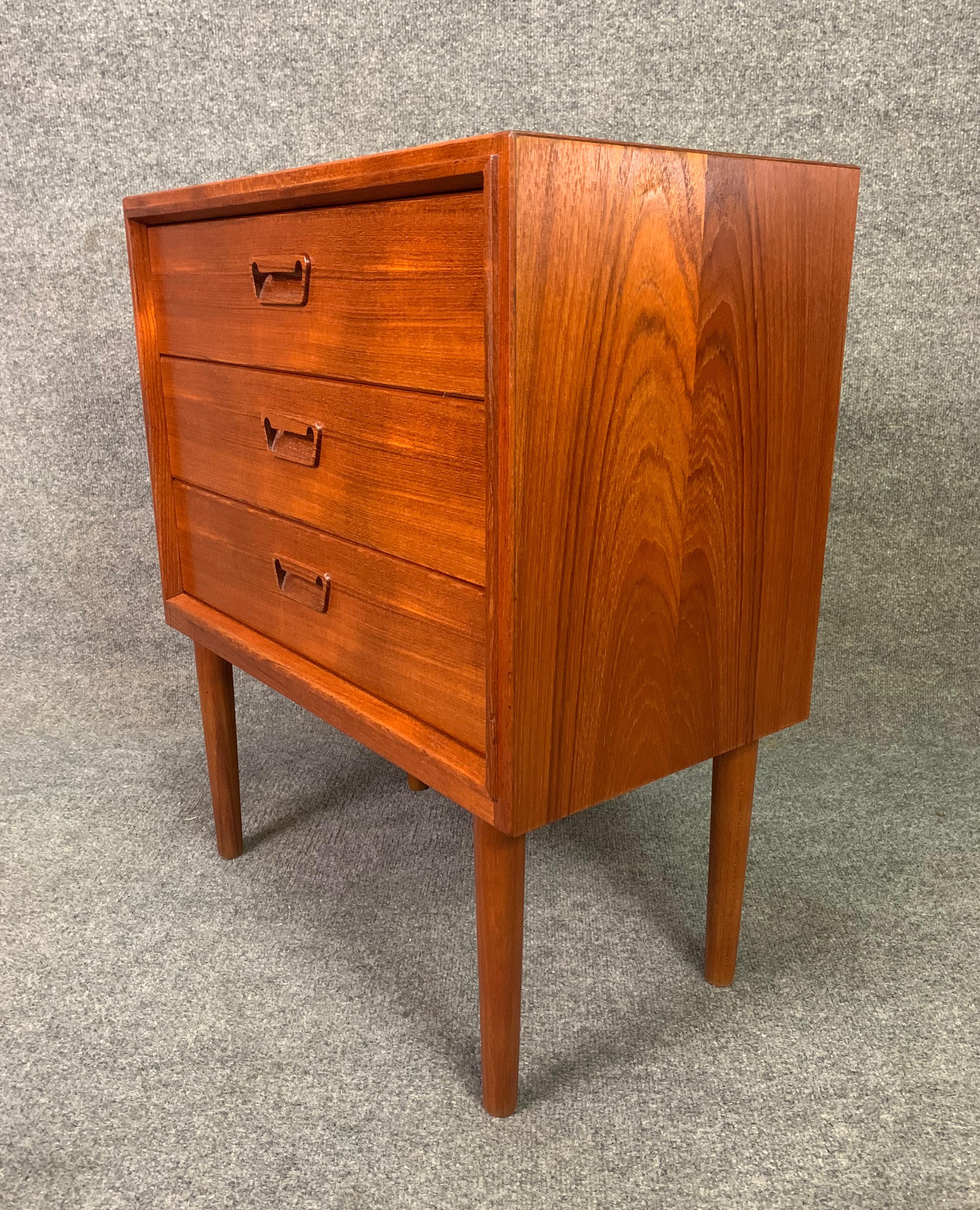Here is a beautiful Scandinavian Modern small chest in teak manufactured in Denmark in the 1960s by Munch Slagelse.
This fully refinished case piece features a vibrant wood grain, three drawers with sculpted recessed pulls and four solid teak