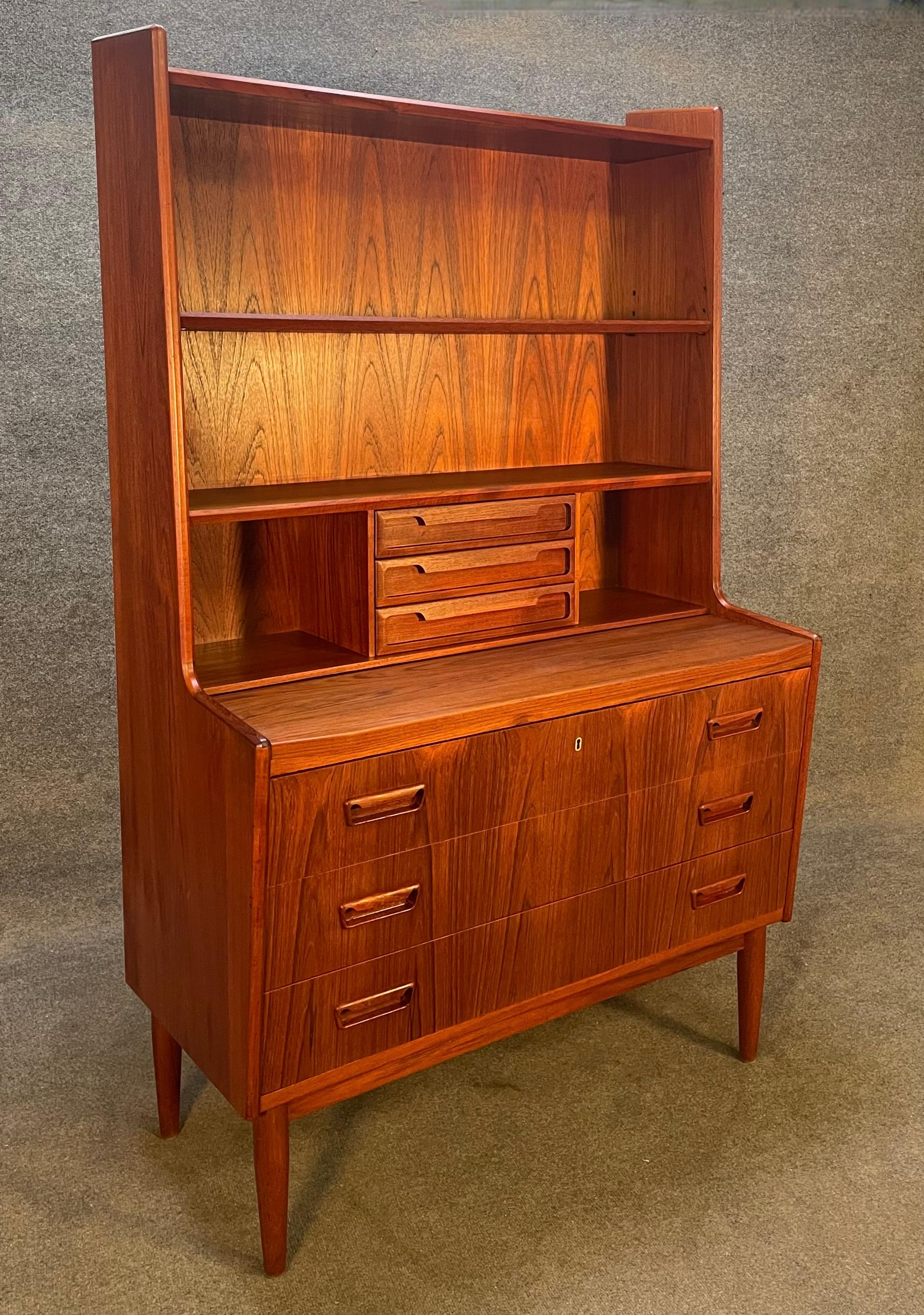 Here is a beautiful 1960's scandinavian modern secretary desk bookcase in teak wood recently imported from Europe to California before its refinishing.
This exquisite piece features a vibrant wood grain, two adjustable shelves, a central bank of