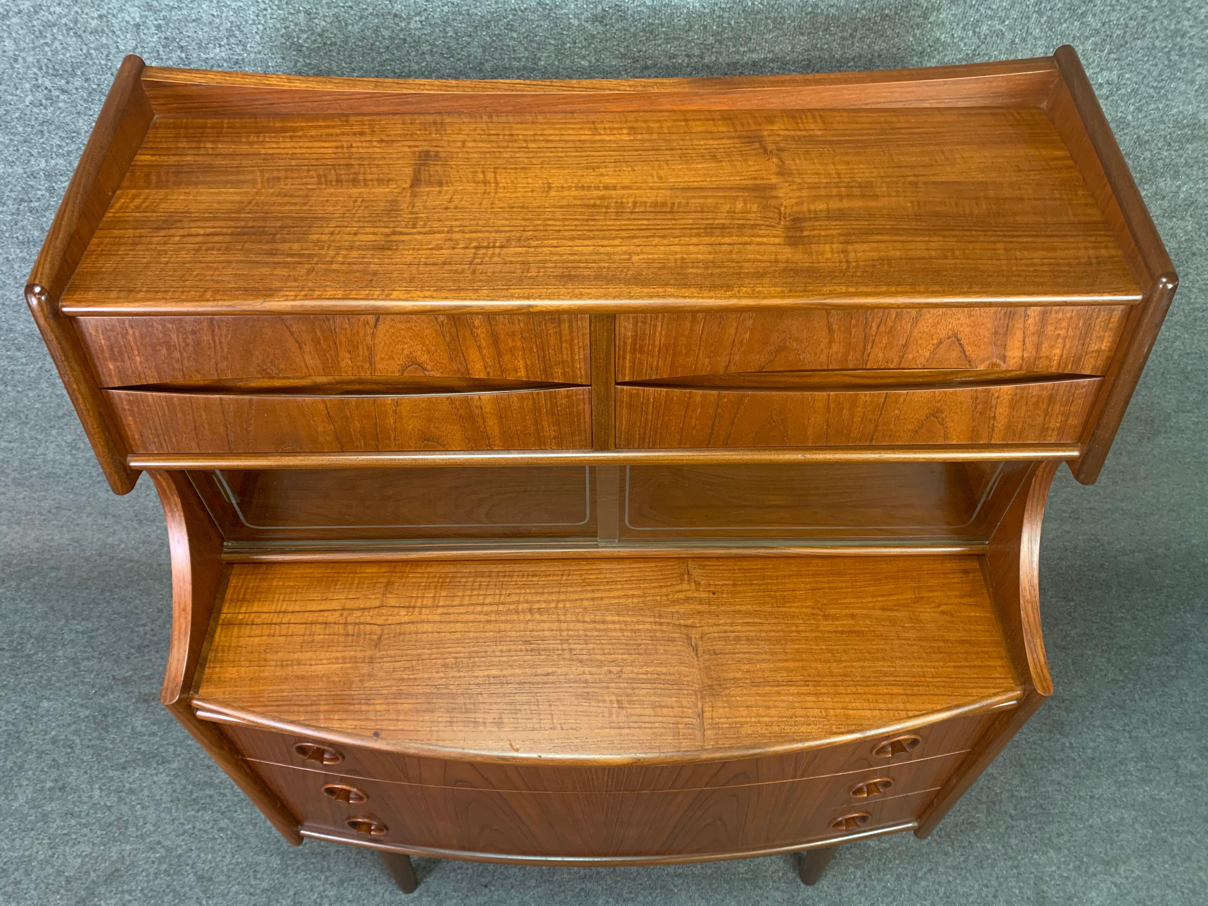 Here is an exquisite 1960s secretary desk in teak wood attributed to famed designer Arne Vodder recently imported from Denmark to California. On its lower side, this case good features beautiful detail in carved handles of all three stacked dovetail