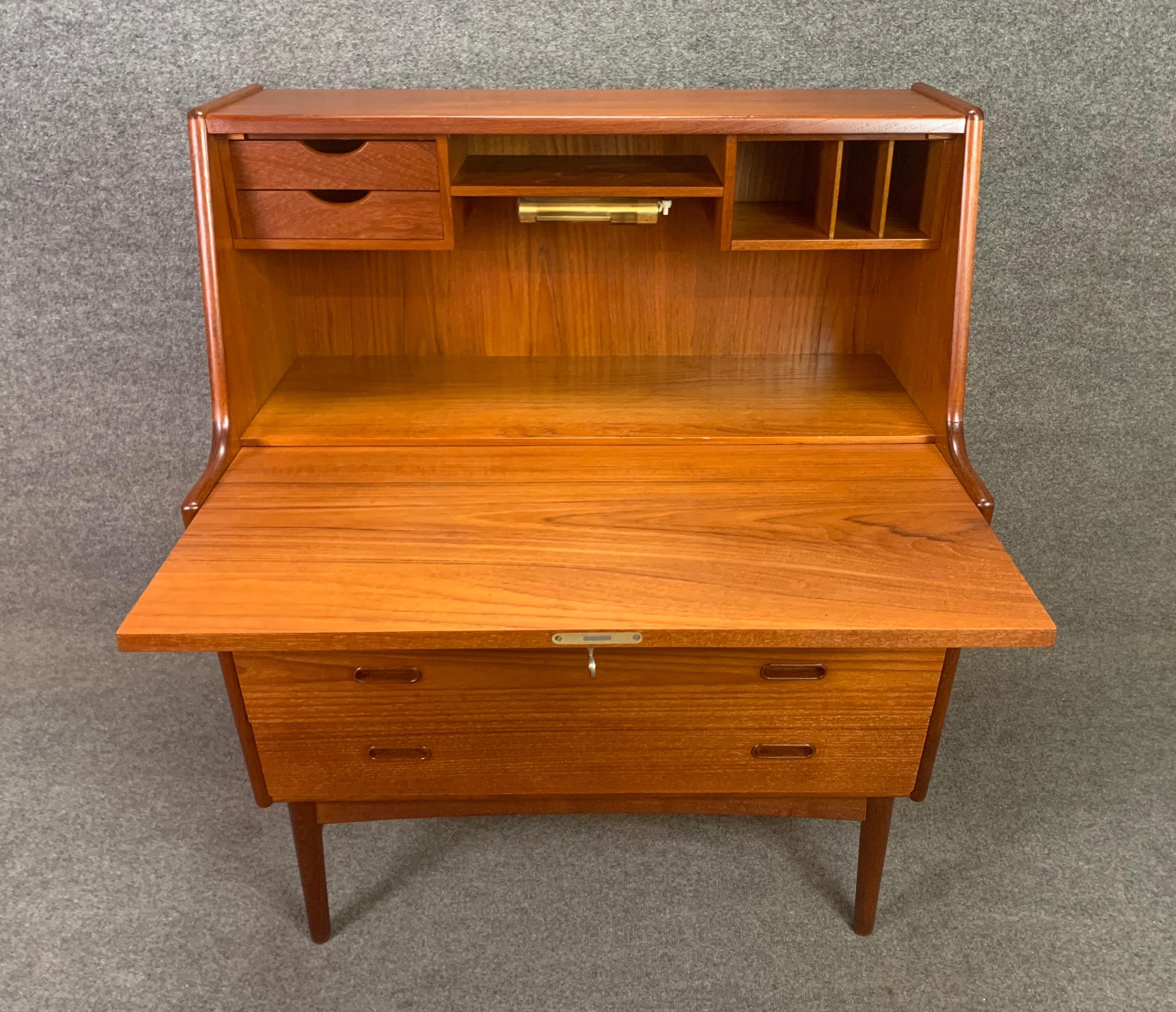 Here is a beautiful Scandinavian Modern teak secretary desk designed by Arne Walh Iversen and manufactured by Vinde Mobelfabrik in Denmark in the 1960s.
This sculptural case piece, recently imported from Copenhagen to California before its
