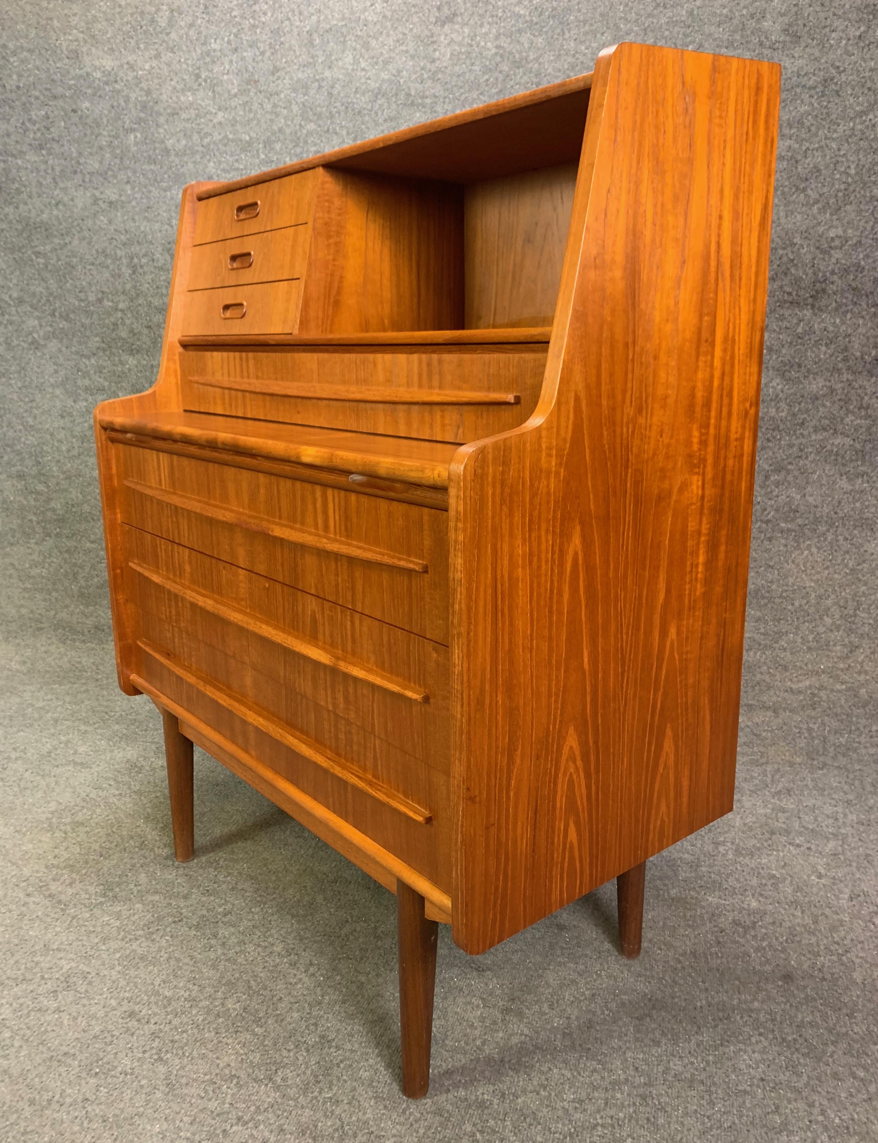 Here is a beautiful Scandinavian secretary desk in teak manufactured by Gunnar Falsigs in Denmark in the 1960s. This exquisite piece, recently imported from Copenhagen to California, features a vibrant wood grain with many storage options: On its