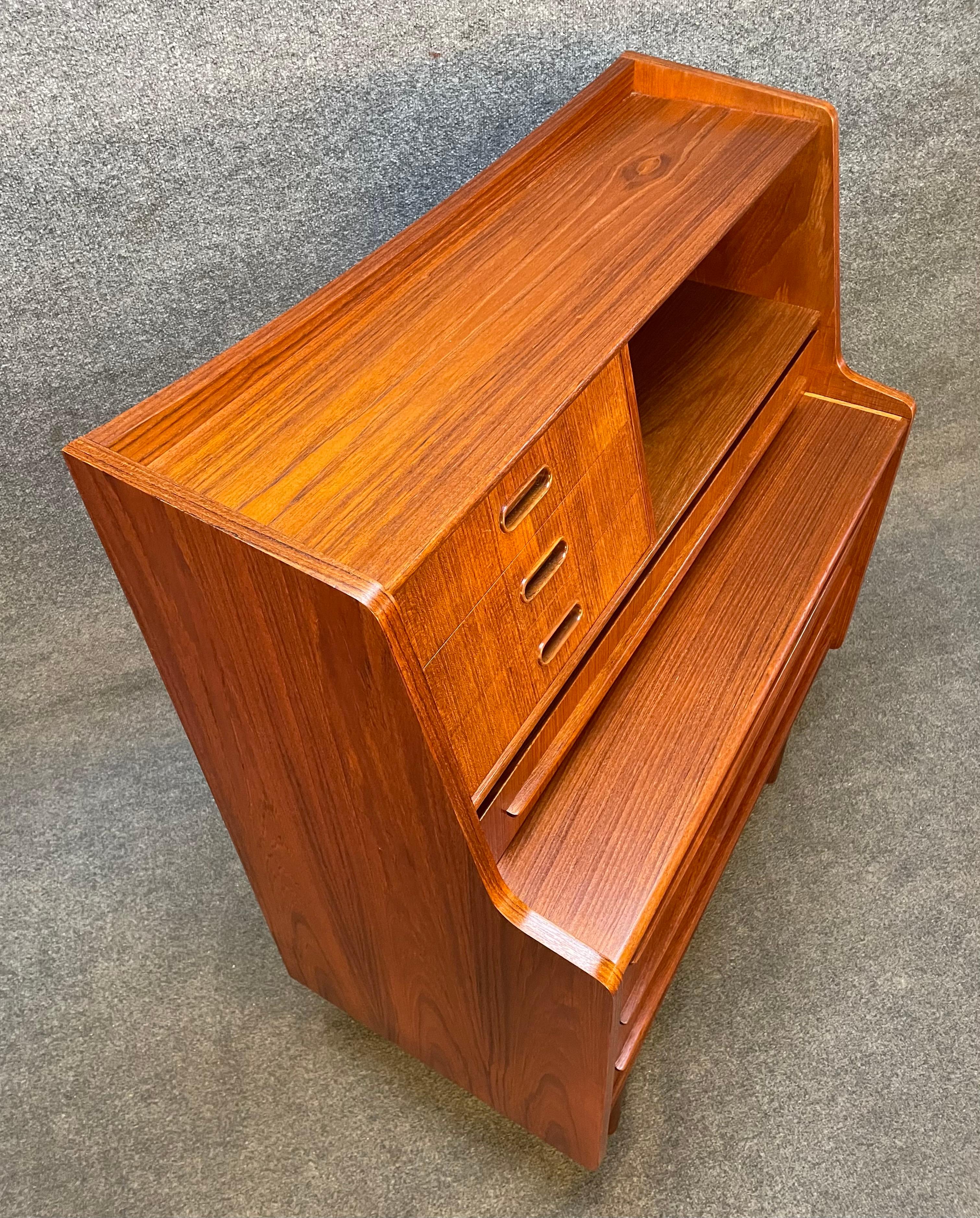 Here is a beautiful Scandinavian secretary desk in teak manufactured by Gunnar Falsigs in Denmark in the 1960s. This exquisite piece, recently imported from Copenhagen to California, features a vibrant wood grain with many storage options: On its