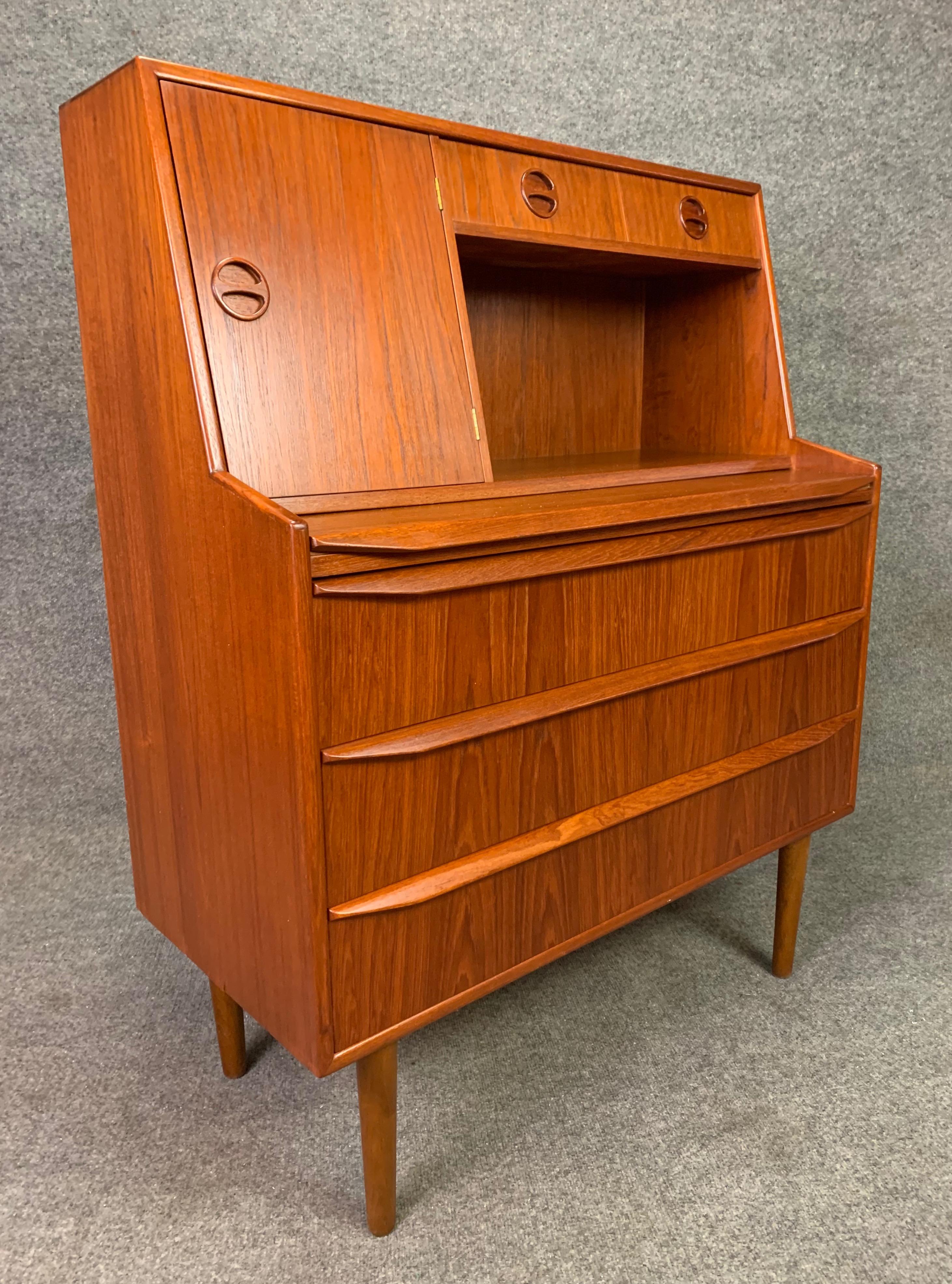 Here is a beautiful 1960s Scandinavian Modern secretary desk in teak recently imported from Denmark to California.
This piece, just cleaned up and oiled, features at its top a door revealing a mirror and a cubby with one shelf and two drawers with