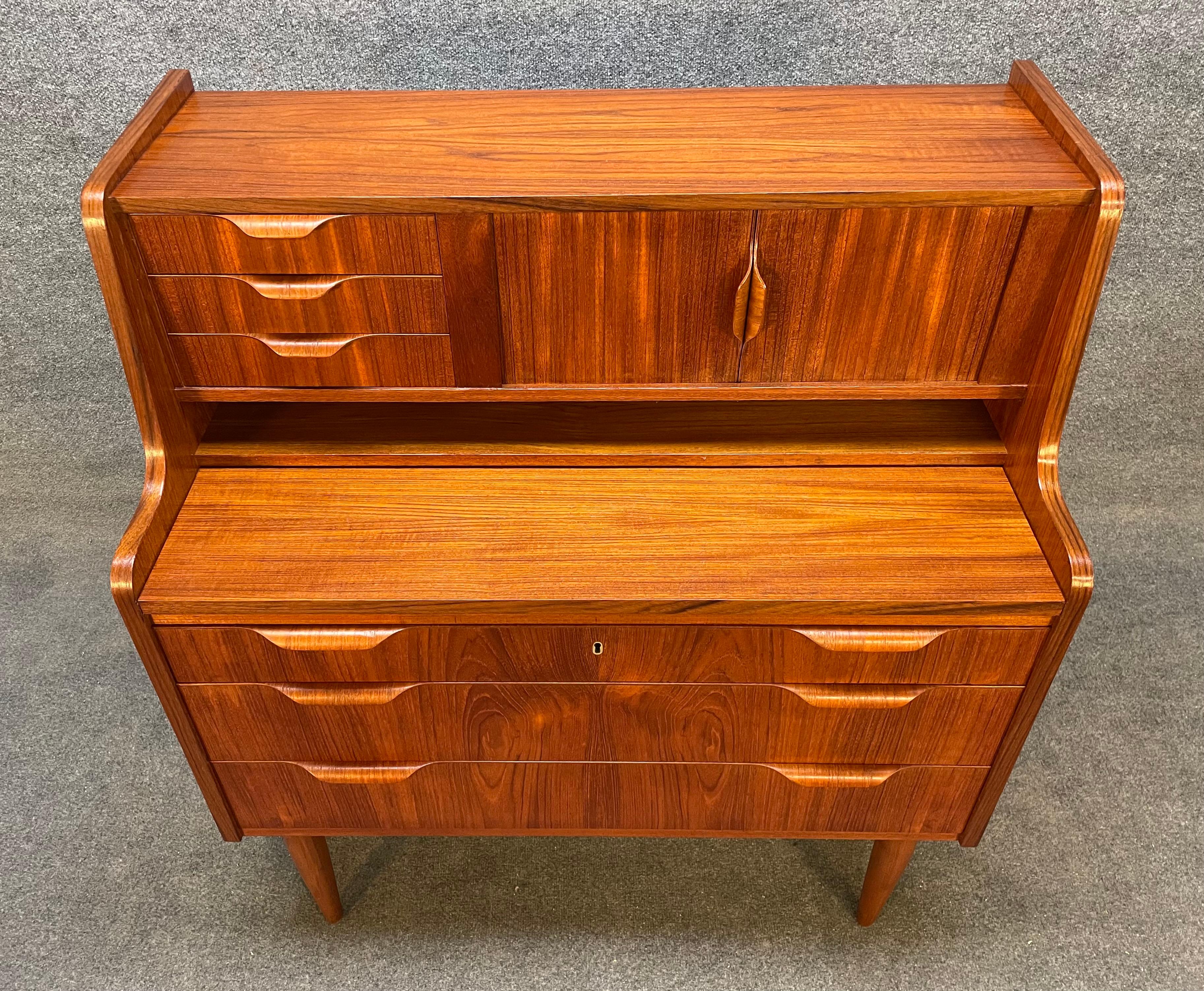 Here is a beautiful Scandinavian modern secretary desk in teak wood manufactured in Denmark in the 1960's.
This exquisite piece, recently imported from Europe to California before its refinishing, features a vibrant wood grain, multiple storage