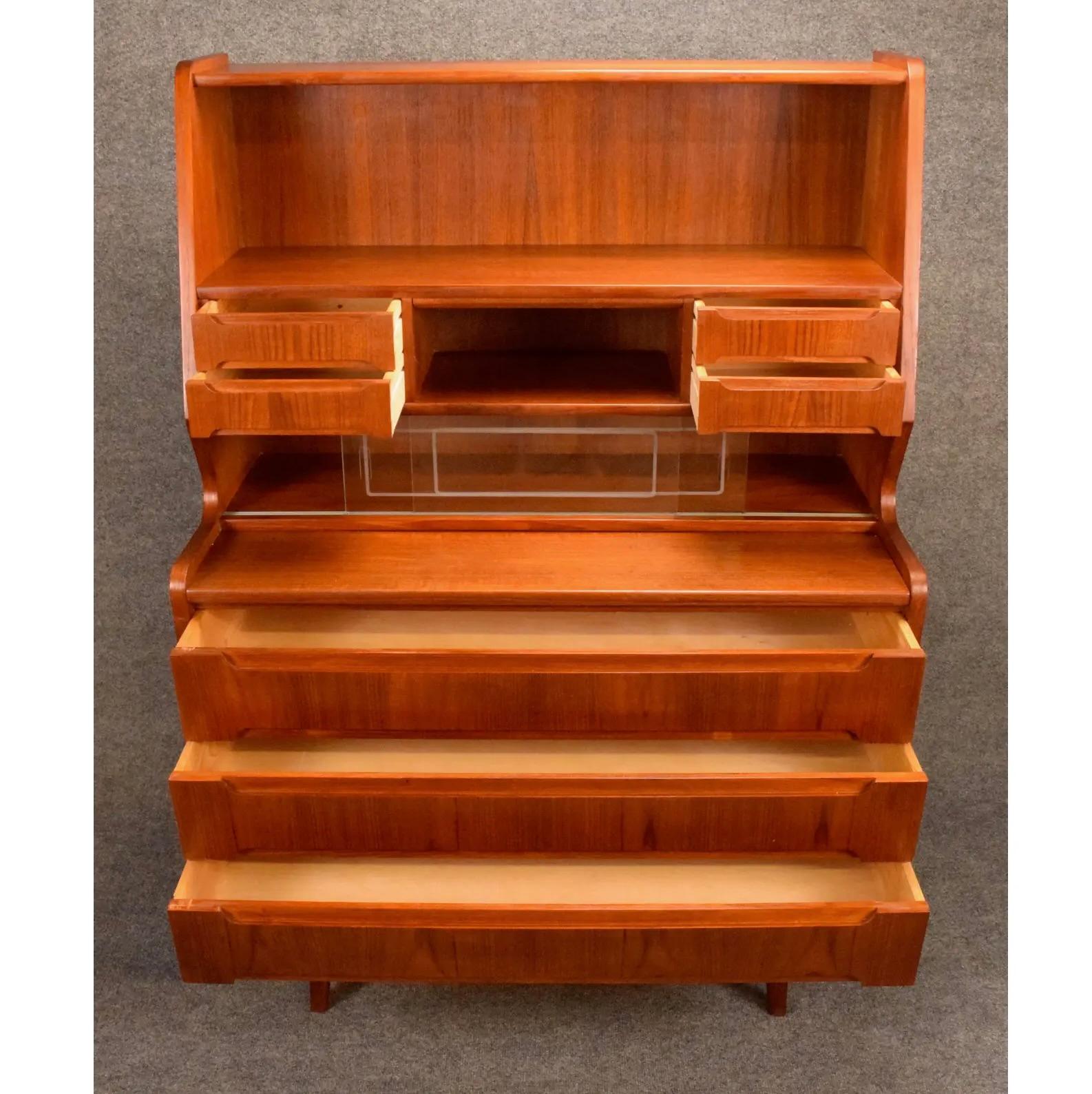 Here is a beautiful scandinavian modern teak secretary desk manufactured in Denmark inn the 1960's that was recently imported from Europe to California before its restoration. 
This exquisite storage piece features vibrant wood grains details + a