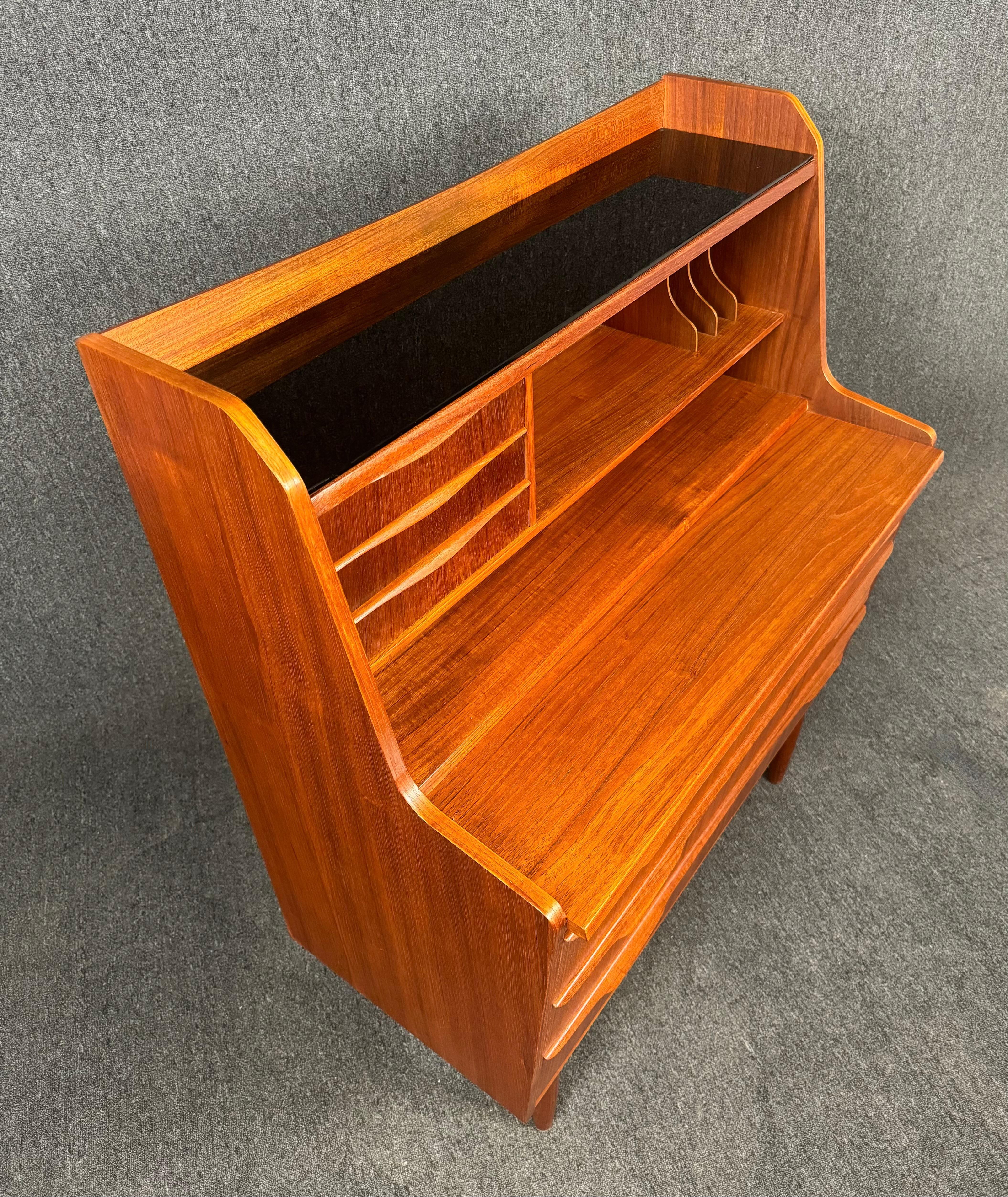 Hier ist ein schöner skandinavisch-moderner Sekretär aus Teakholz, der vor kurzem aus Dänemark nach Kalifornien importiert wurde, bevor er neu lackiert wurde. Dieses exquisite Stück zeichnet sich durch eine lebendige Holzmaserung, eine Reihe von 3