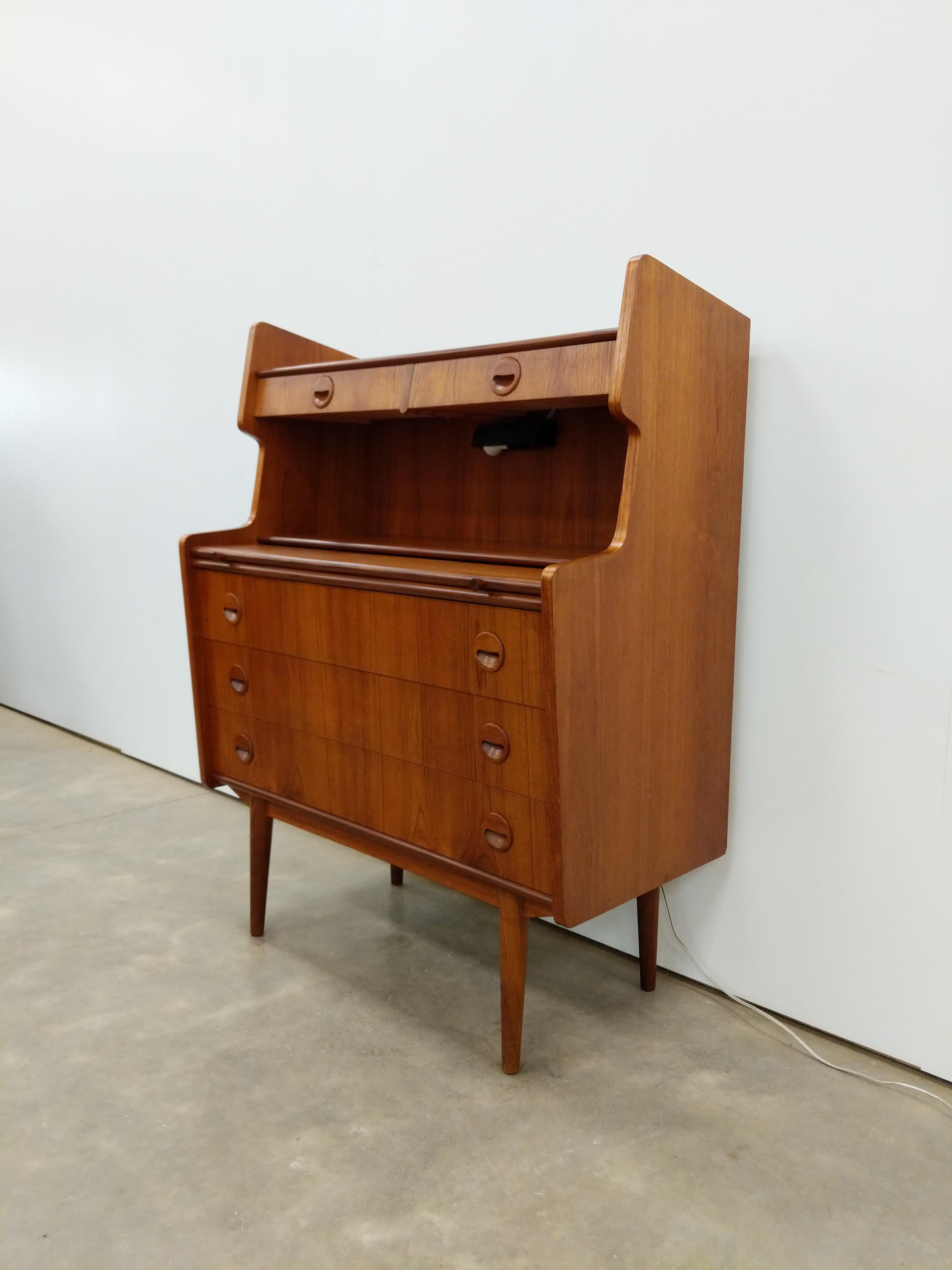 Authentique bureau secrétaire / commode / commode en teck du milieu du siècle dernier de style danois / The Modern Scandinavian.

Avec lumière à l'intérieur de la zone ouverte.

Cette pièce est en excellent état avec très peu de signes d'usure liés