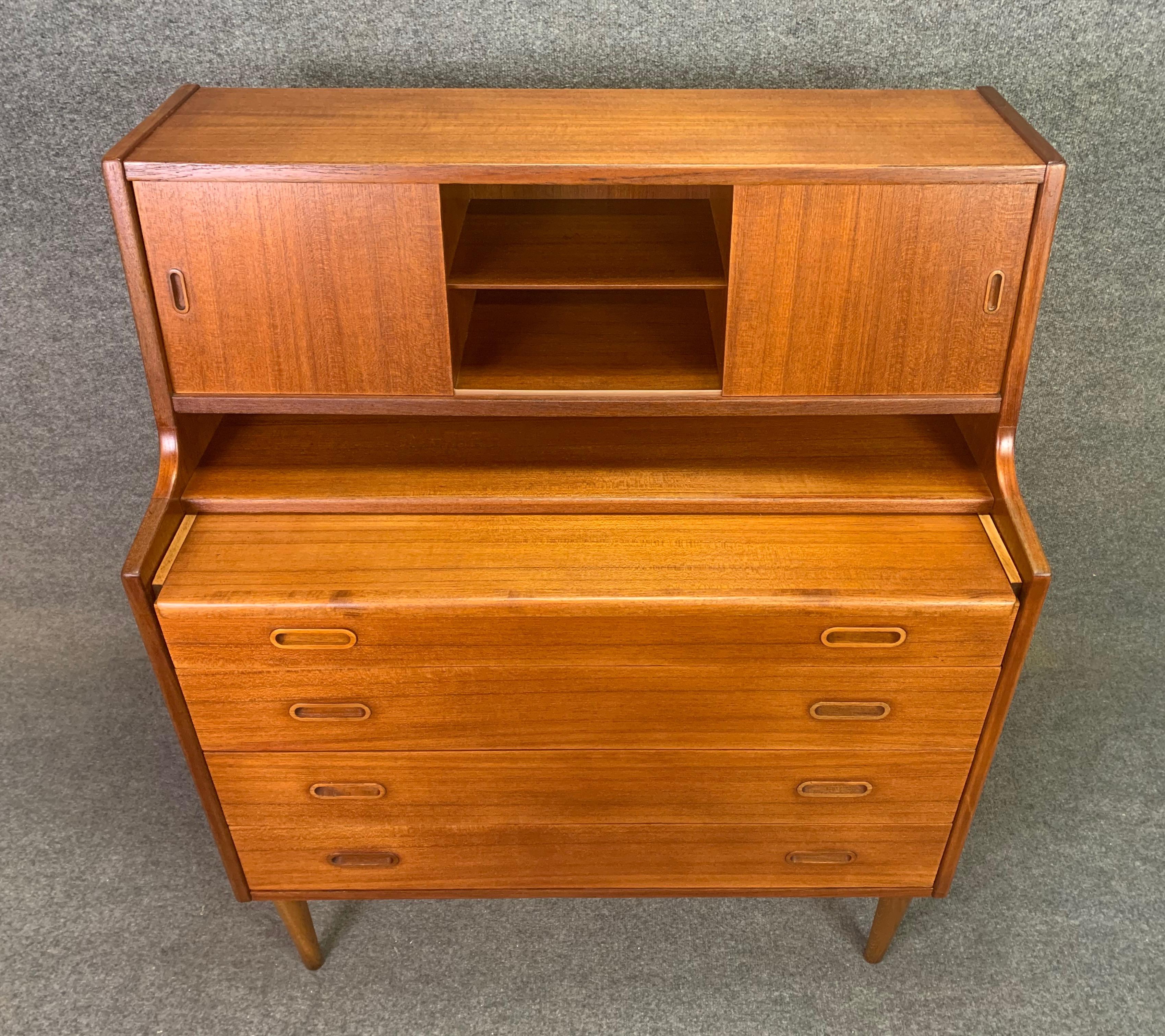 Here is a beautiful 1960s Scandinavian modern teak secretary desk recently imported from Denmark to California before its refinishing.
This very versatile case piece features a slide out drawer exposing a writing desk surface that lifts up to