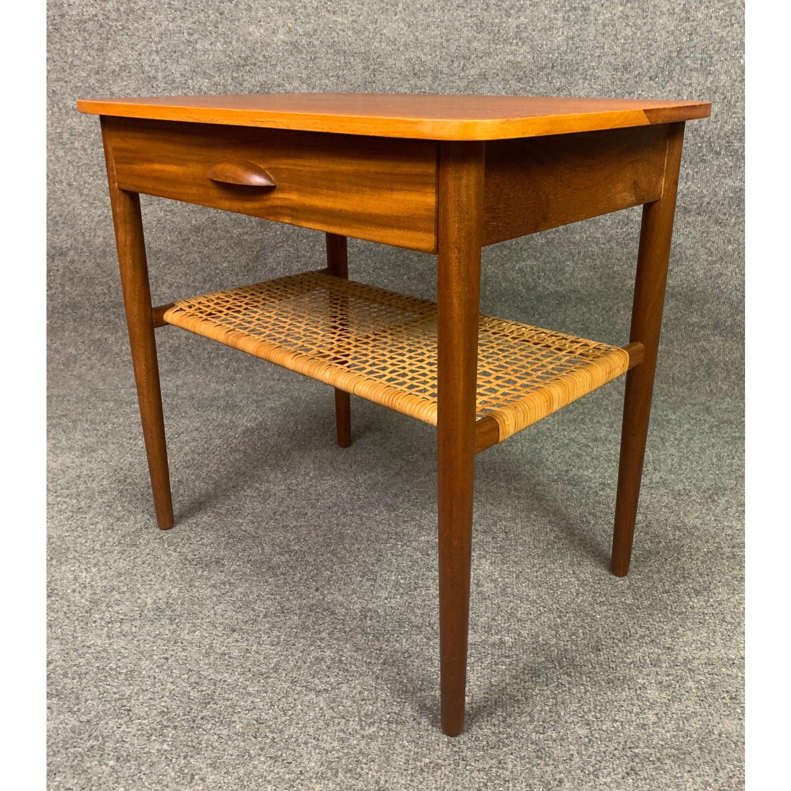 Here is a lovely 1960s Scandinavian Modern end table in teak recently imported from Denmark to California before its refinishing.
This side table features a vibrant teak wood grain, one drawer and one cane shelf.
Excellent condition.
Dimensions: