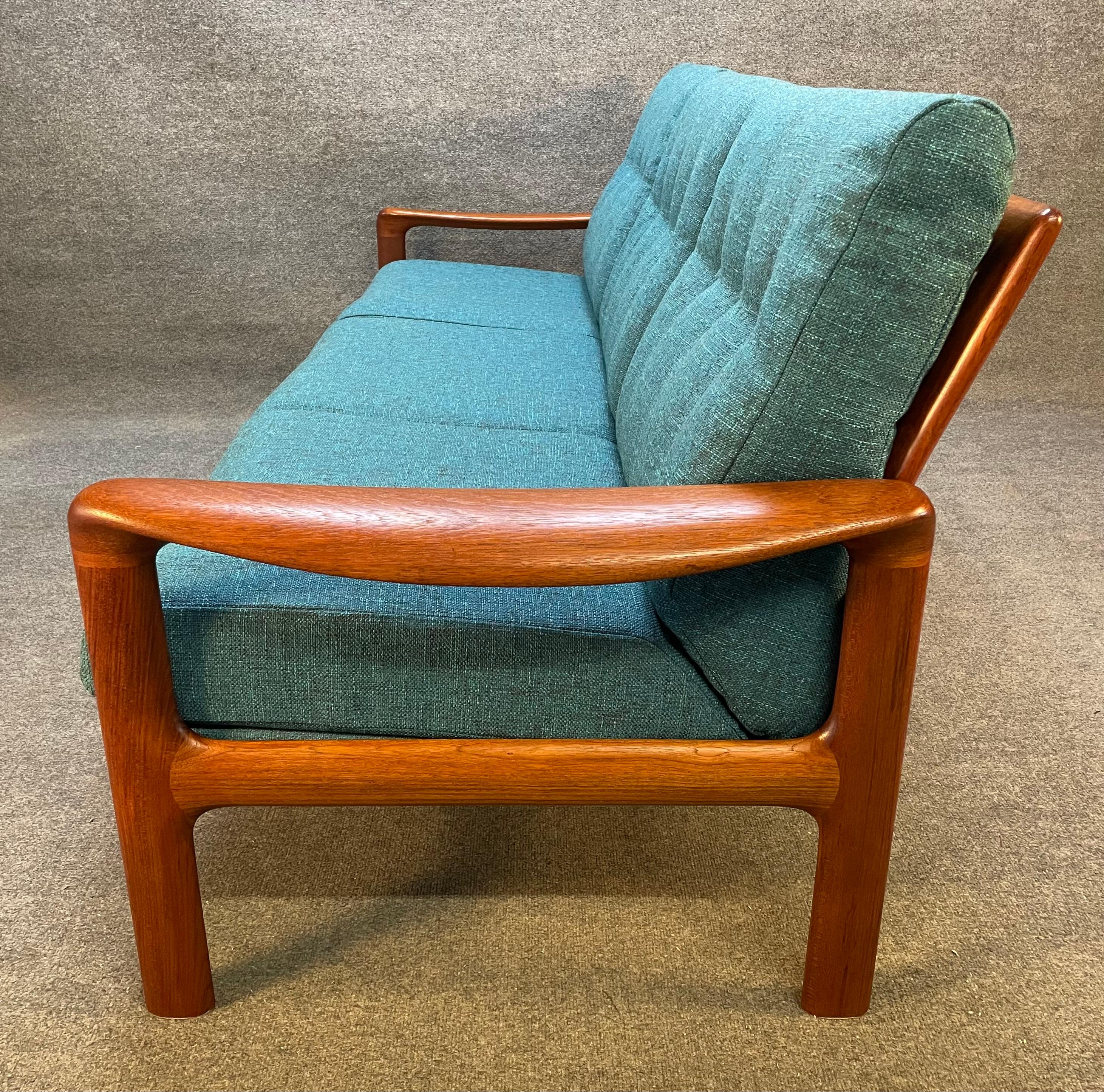 Here is a beautiful scandinavian modern 3 seaters sofa in teak wood manufactured by Komfort in Denmark in the late 1960's.
This comfortable couch, recently imported from Denmark to California before its refinishing, features a solid teak frame with