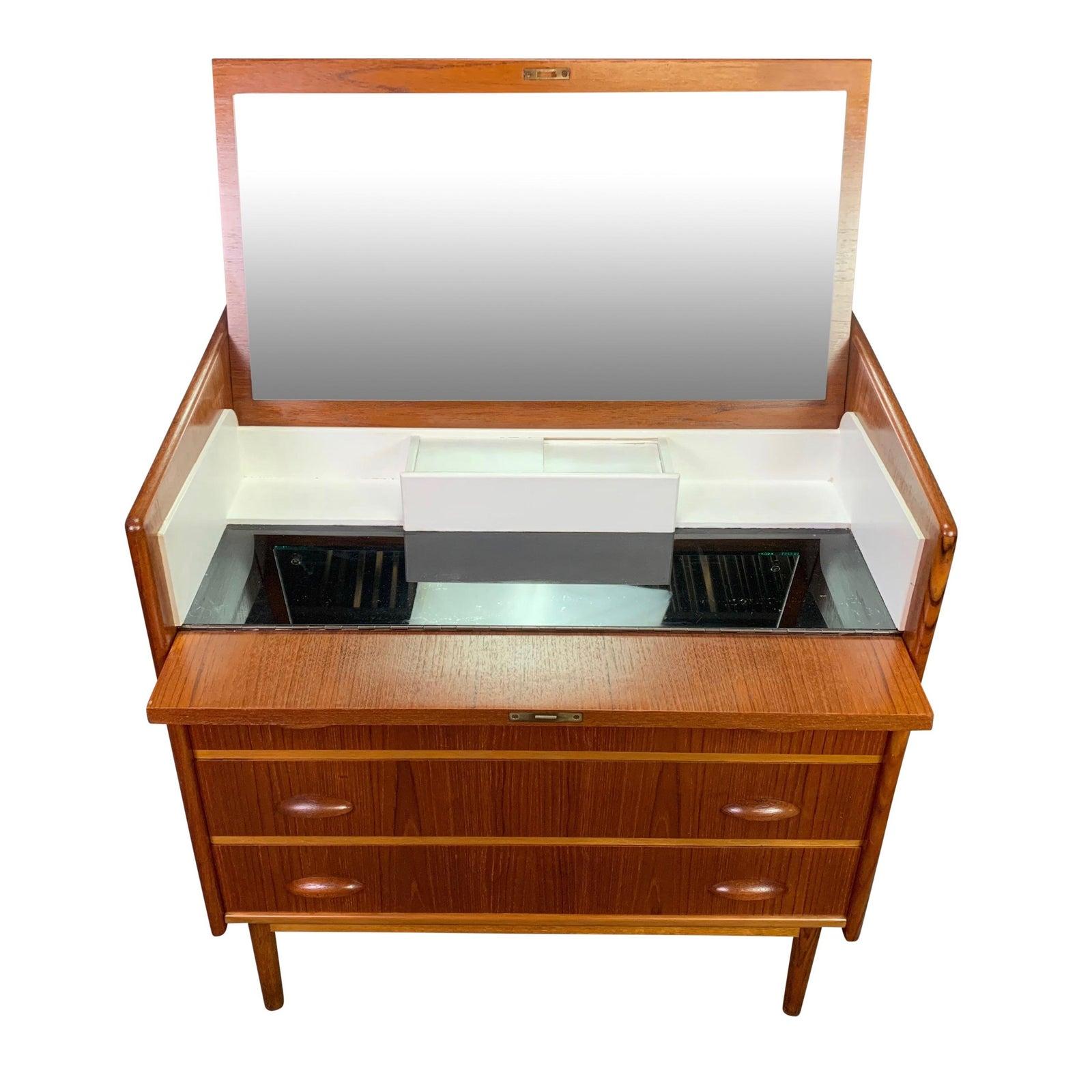 Here is an exquisite Scandinavian Modern dressing table, dresser in teak manufactured in the1960s in Denmark and recently imported to California before its restoration.
This beautiful piece features a lift top and drop down drawer front revealing a