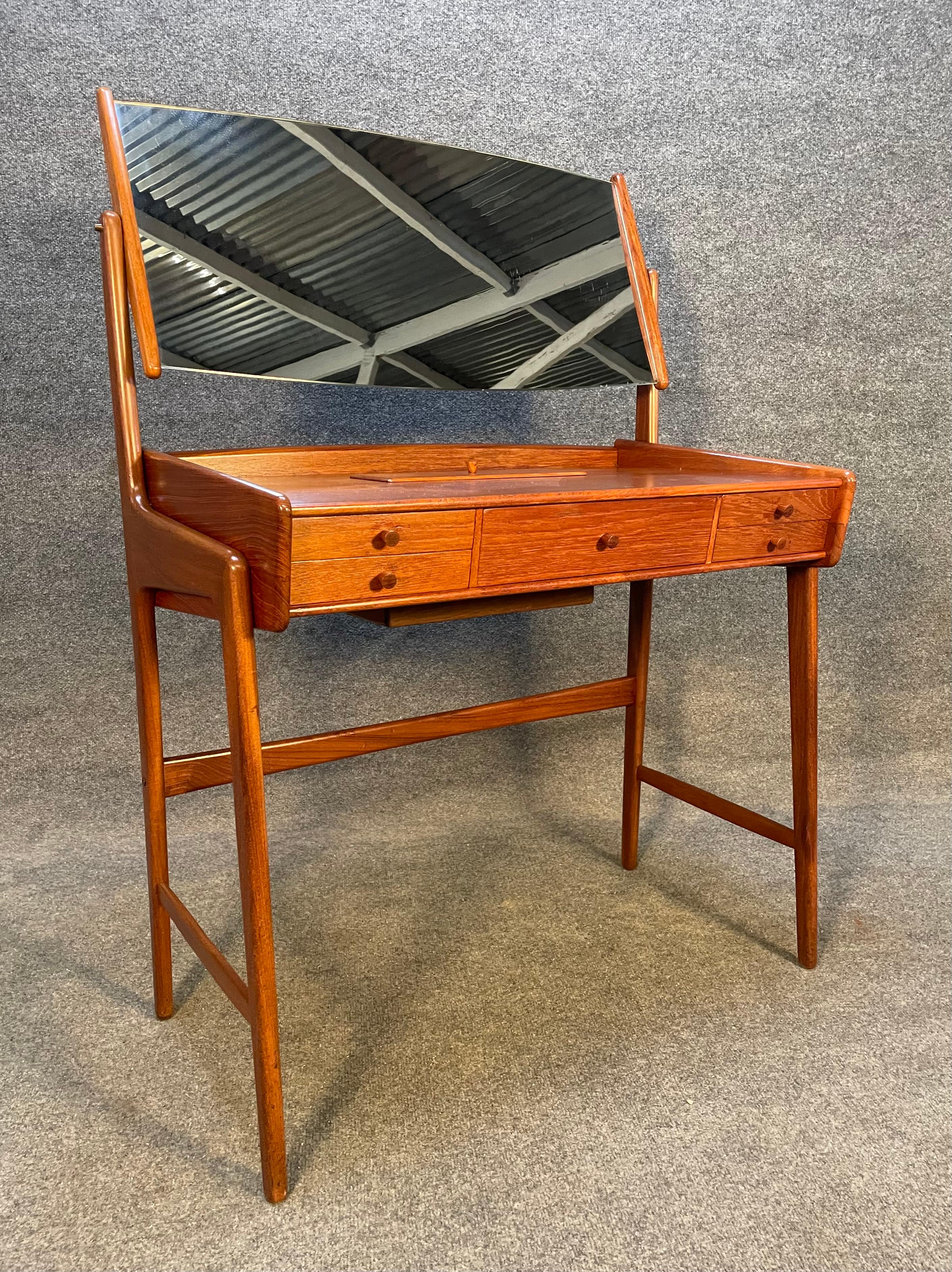 Here is a beautiful 1960's scandinavian modern dressing table in teak wood recently imported from Europe to California before its refinishing.
This exquisite piece features a sculptural frame in solid teak, a tilting adjustable mirror, five drawers