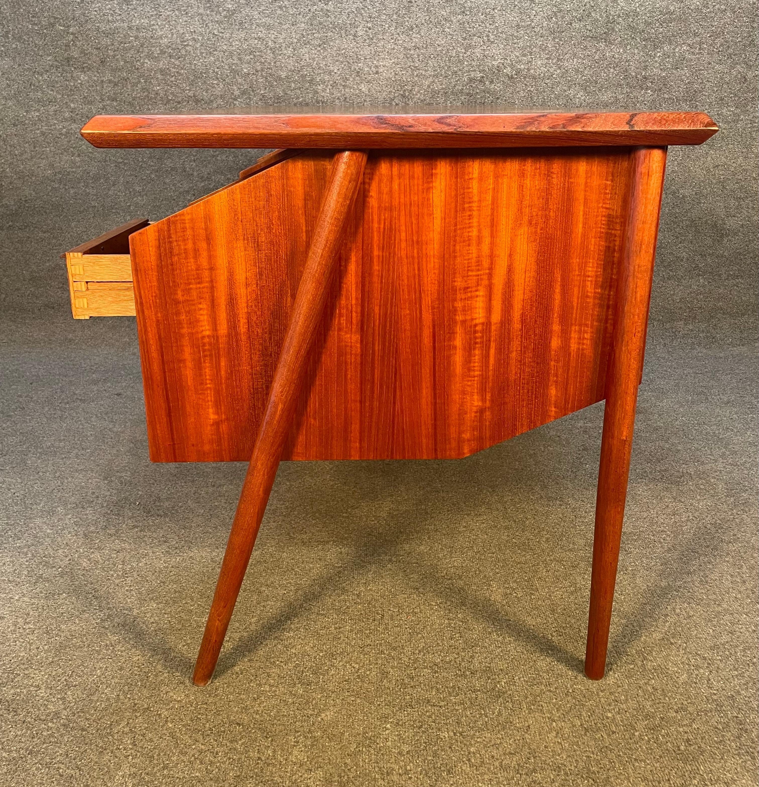 Here is a beautiful Scandinavian modern teak desk manufactured in Denmark in the 1960's recently imported from Europe to California before its refinishing.
This exquisite desk features a large top showing vibrant wood grain, two banks of three dove