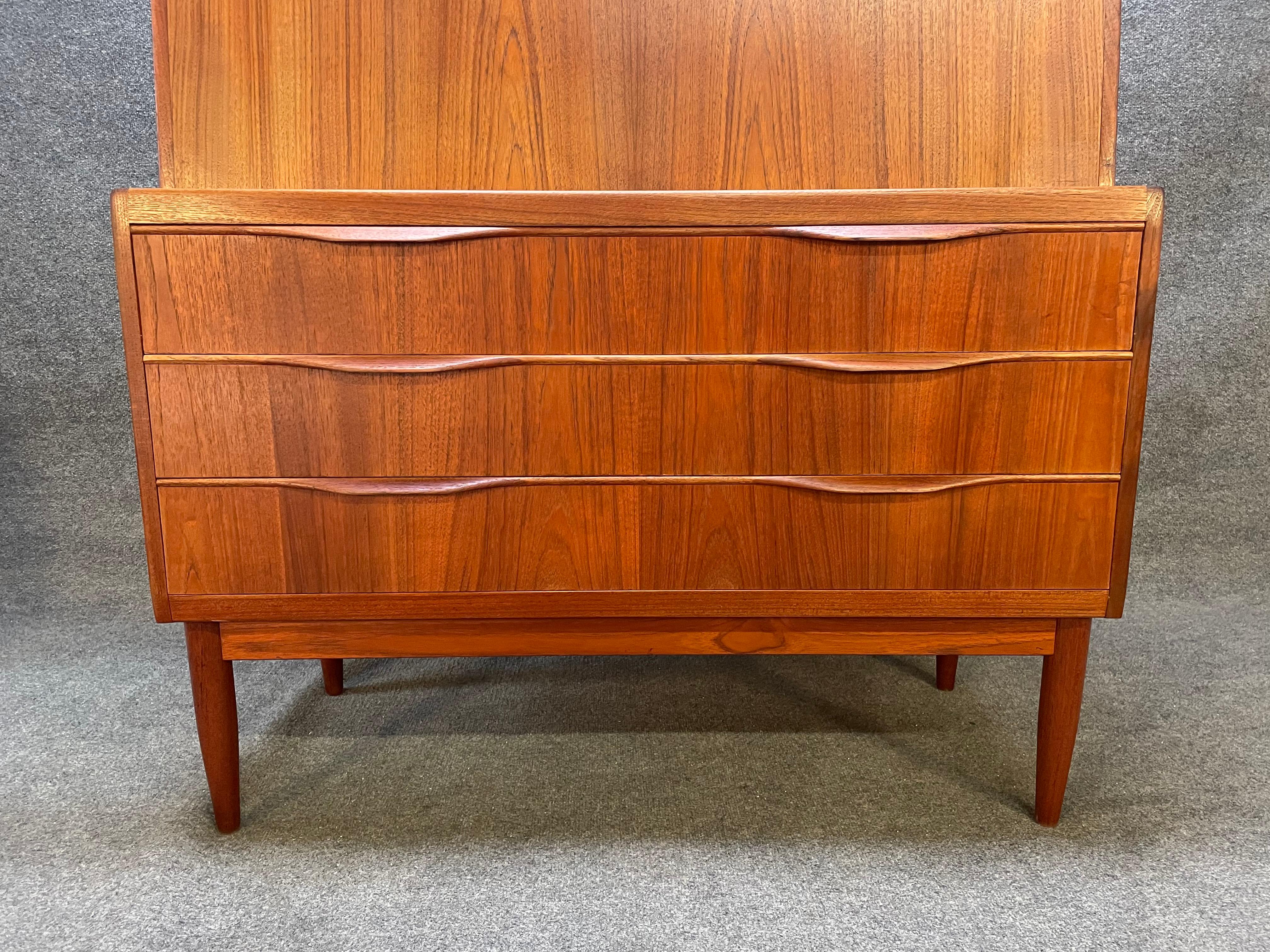 Here is a beautiful Scandinavian modern secretary desk in teak wood designed by Erlingb Torvitz in Denmark in the 1960's. This exquisite piece, recently imported from Europe to California before its refinishing, features a vibrant wood grain, a drop
