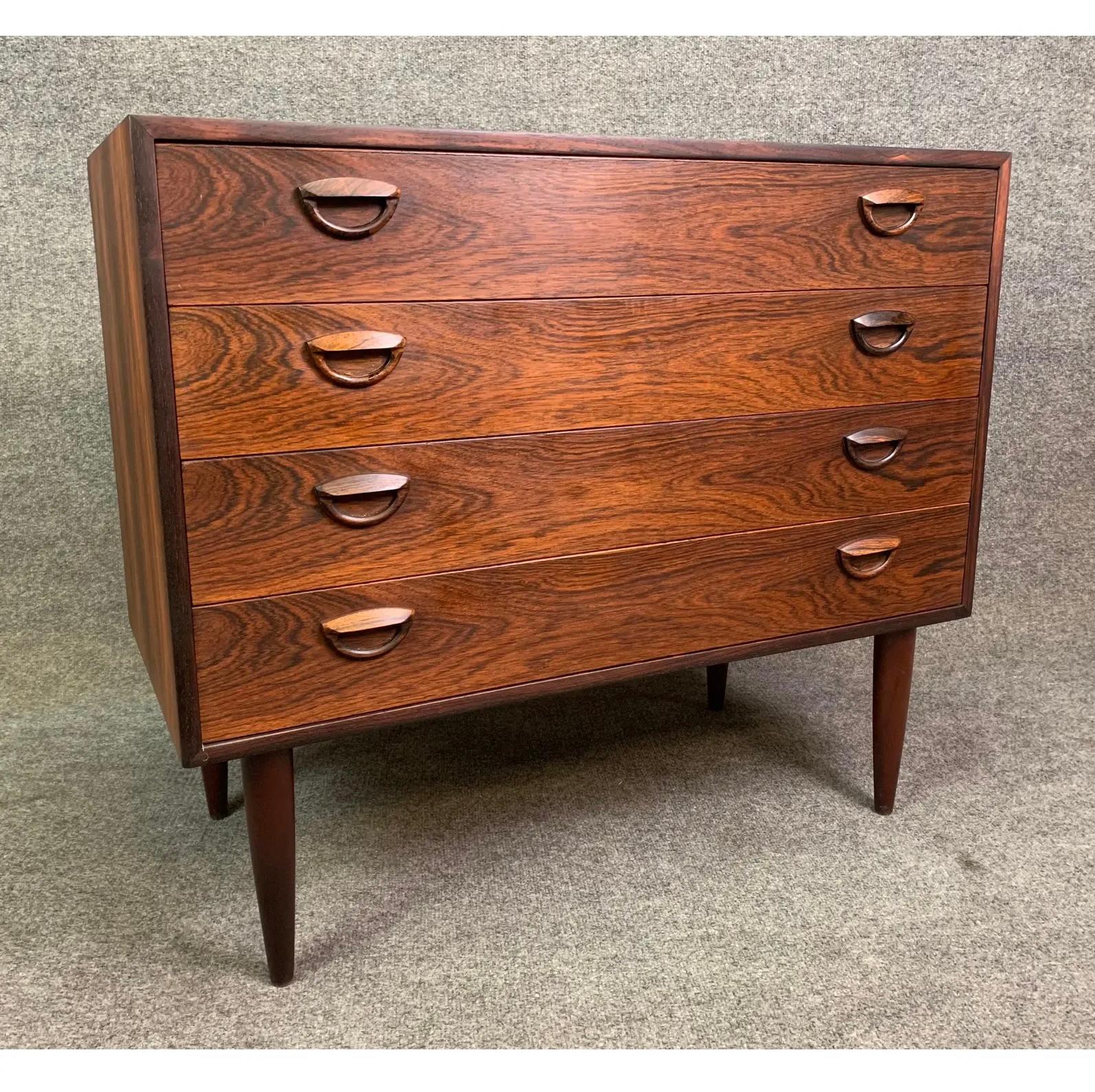 Here is a beautiful Scandinavian modern chest of drawers in Brazilian rosewood designed by Kai Kristiansen and manufactured by Feldballes Mobelfabrik in Denmark in the 1960's. 
This exquisite case piece, recently imported from Europe to California