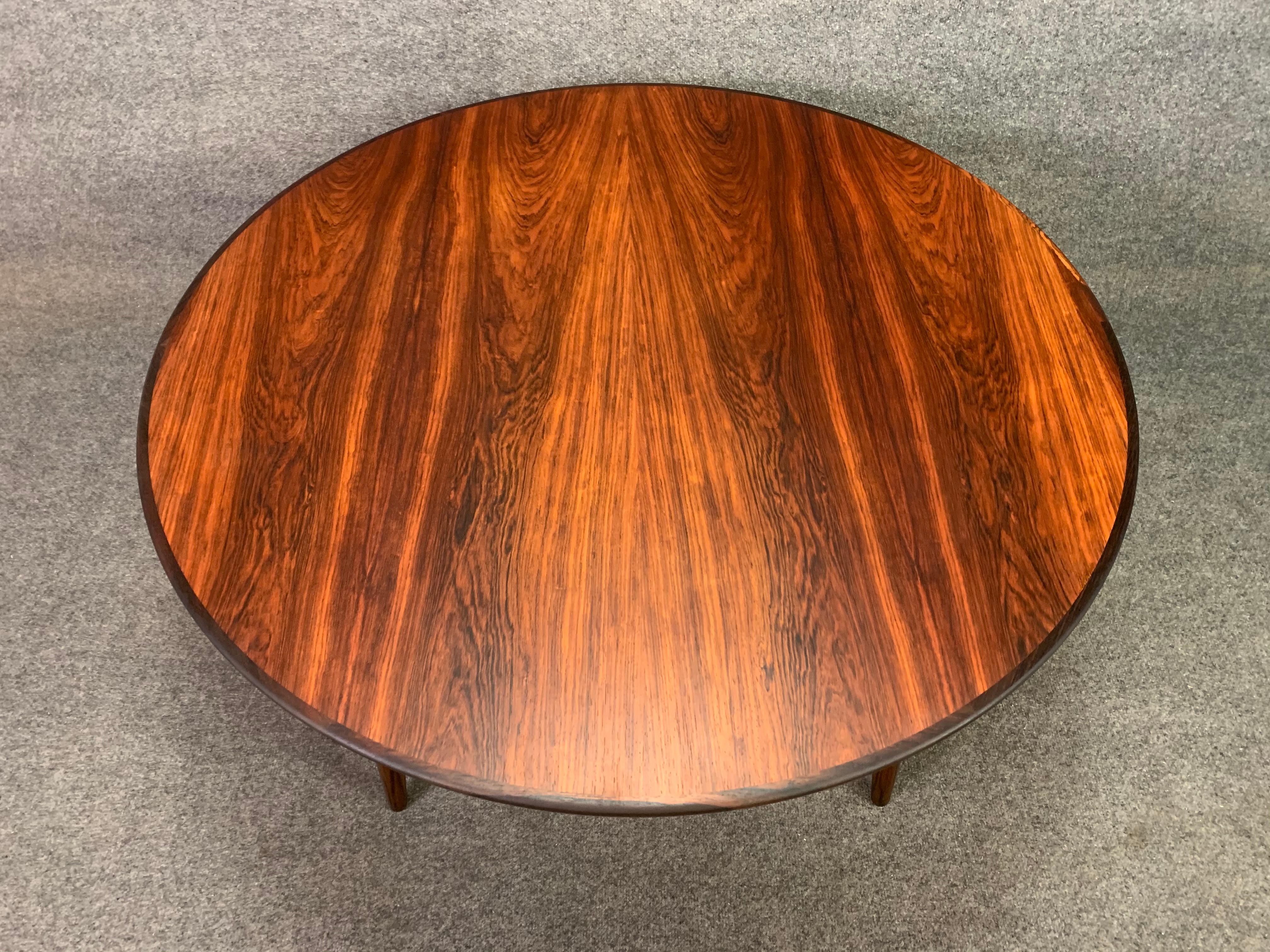 Here is a beautiful 1960s Scandinavian modern cocktail round table in rosewood reminiscent of the design of Johannes Andersen for CFC Mobelfabrik. This exquisite circular table has been fully refinished and features a vibrant rosewood grain on its