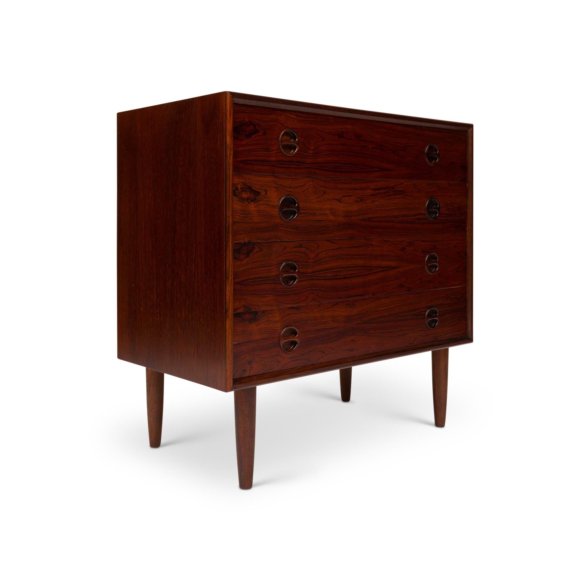 This stunning Danish mid-century rosewood dresser from the 1960s epitomizes timeless design. Its exquisite rosewood-grain detailing and sleek four-drawer structure, accented by circular round pulls, harmonizes form and functions flawlessly.