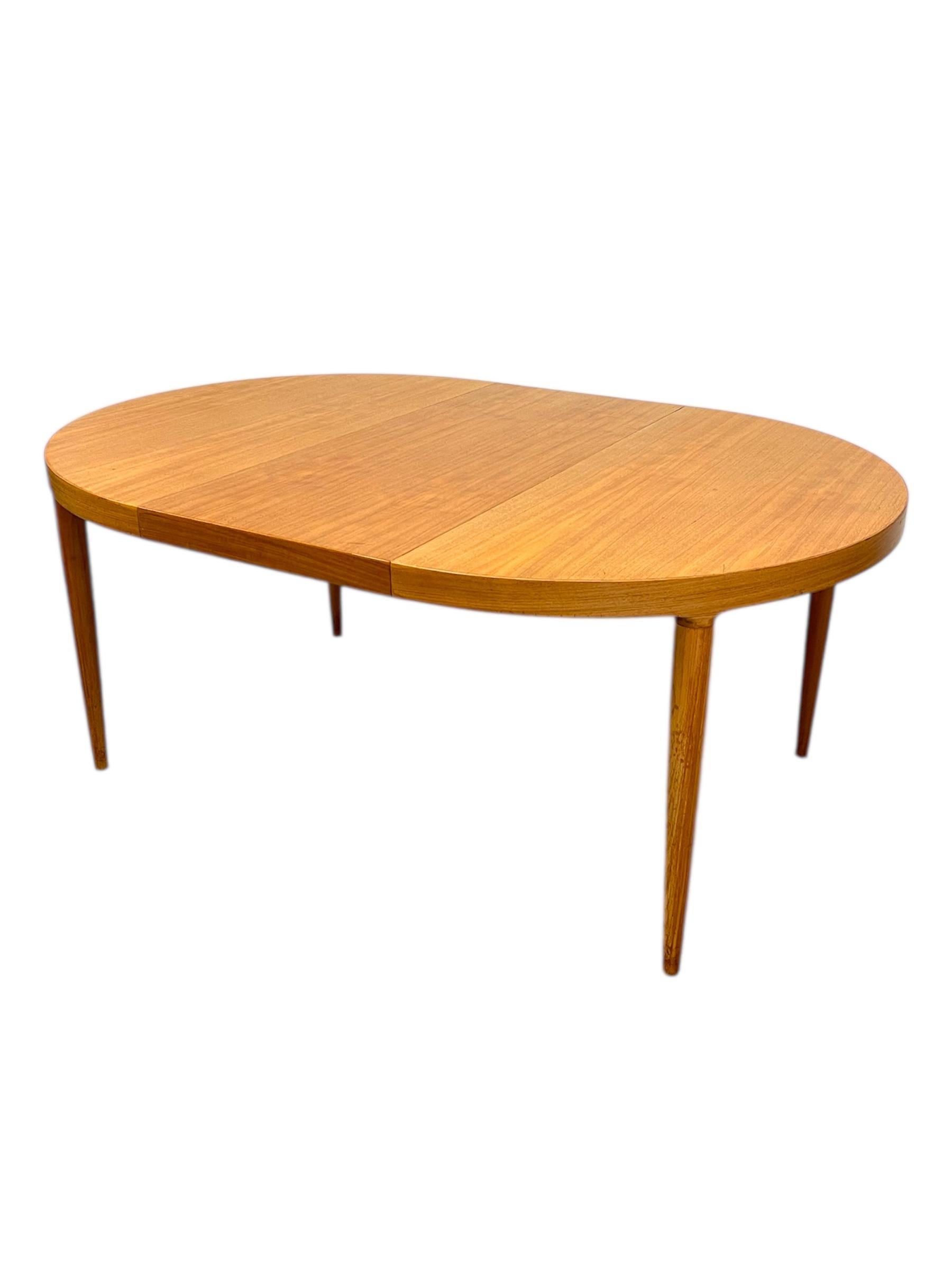 This vintage Danish dining table, designed by Skovmand & Andersen for Moreddi, exemplifies the clean lines and timeless craftsmanship of mid-century modern design. Crafted in Denmark, the table showcases warm wood grain and elegant tapered legs,