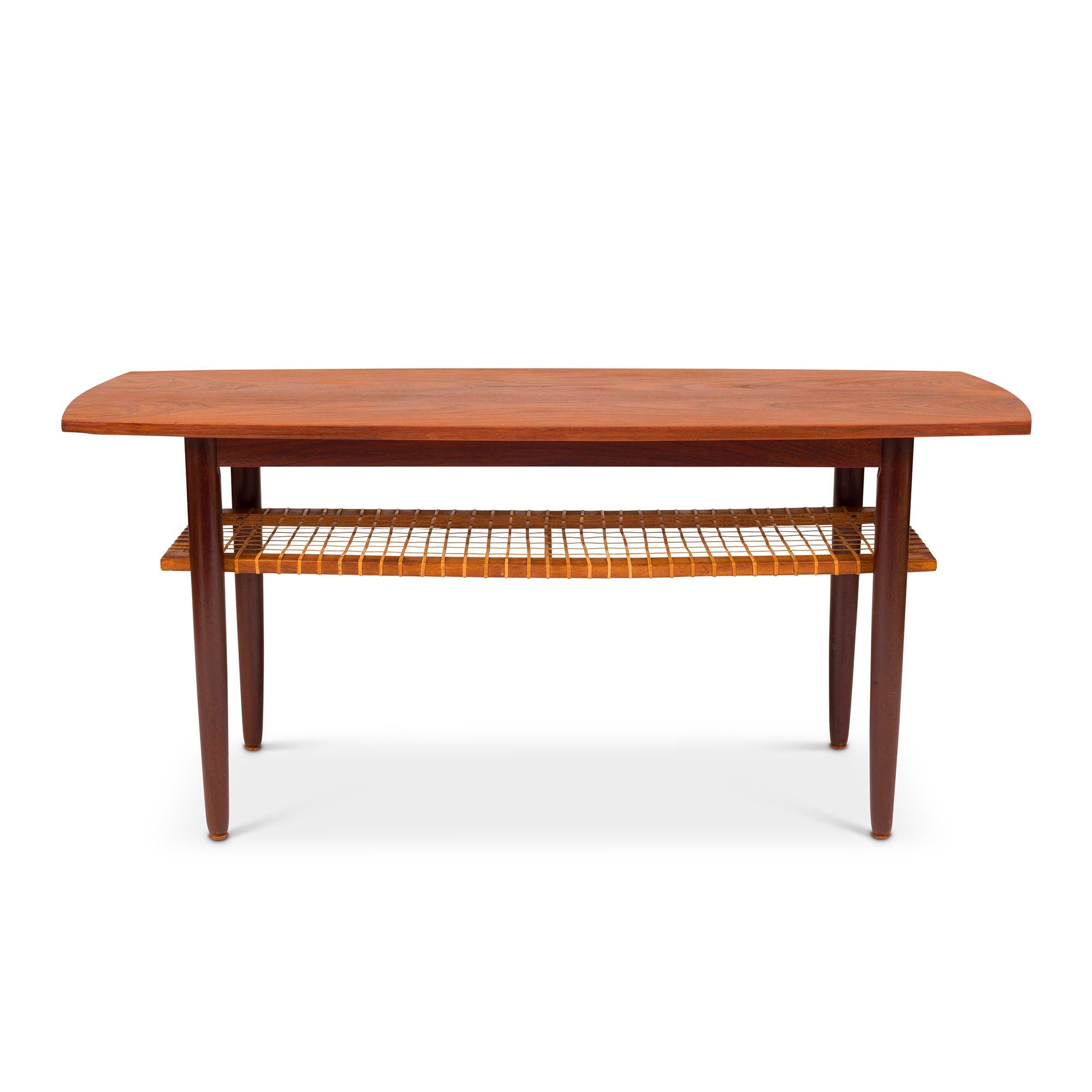 The teak and cane Danish coffee table is a stylish and versatile piece of furniture emblematic of mid-century modern design. Characterized by its clean lines, elegant simplicity, and expert craftsmanship, this coffee table typically features a