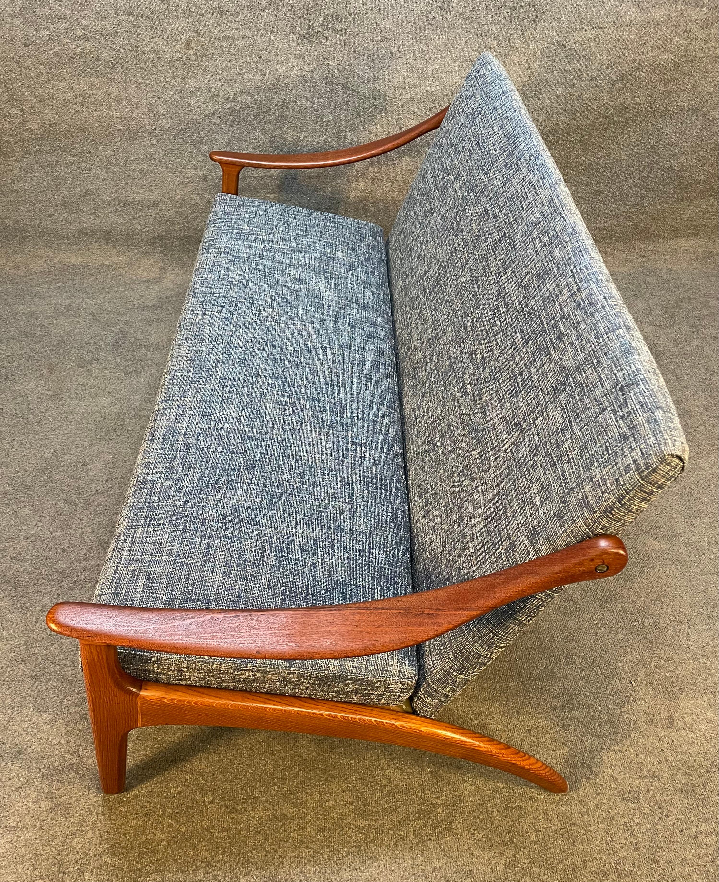 Here is a rare and beautiful Scandinavian modern settee in teak and oak designed by Arne Hovmand Olsen and manufactured by Mogens Kold in Denmark in the 1960's.
This exquisite piece, recently imported from Europe to California before its