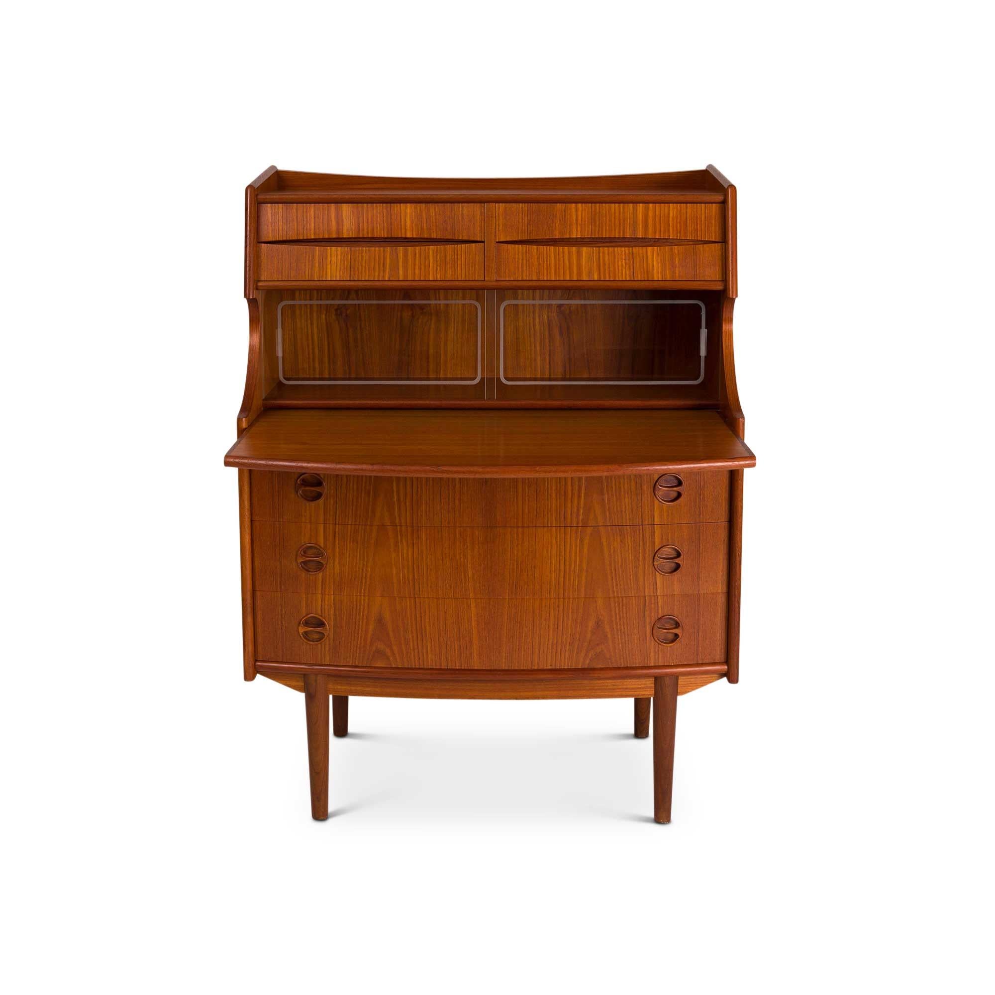 A beautiful Danish teak bureau circa the 1960s with a beautiful teak grain throughout. This bureau features a raised back with two four smaller drawers on top, two sliding etched glass doors over a sliding writing surface, three drawers, and four