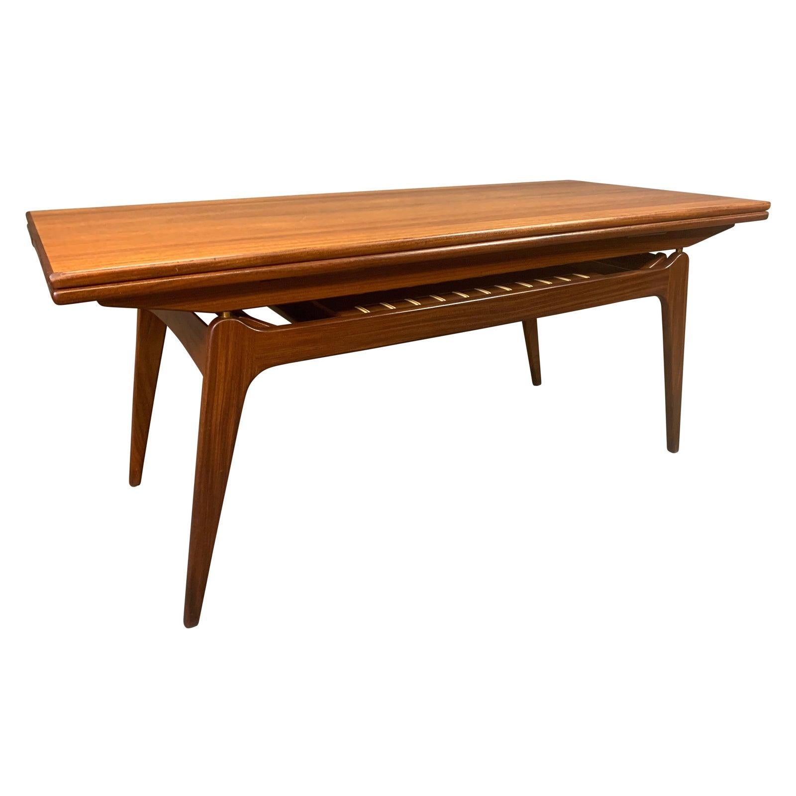 Here is a beautiful Scandinavian Modern elevator table in teak and afromasia wood manufactured in Denmark in the 1960 by B.C. Mobler.
This clever design allows the table to raise and extend from a regular size coffee table into a regular size