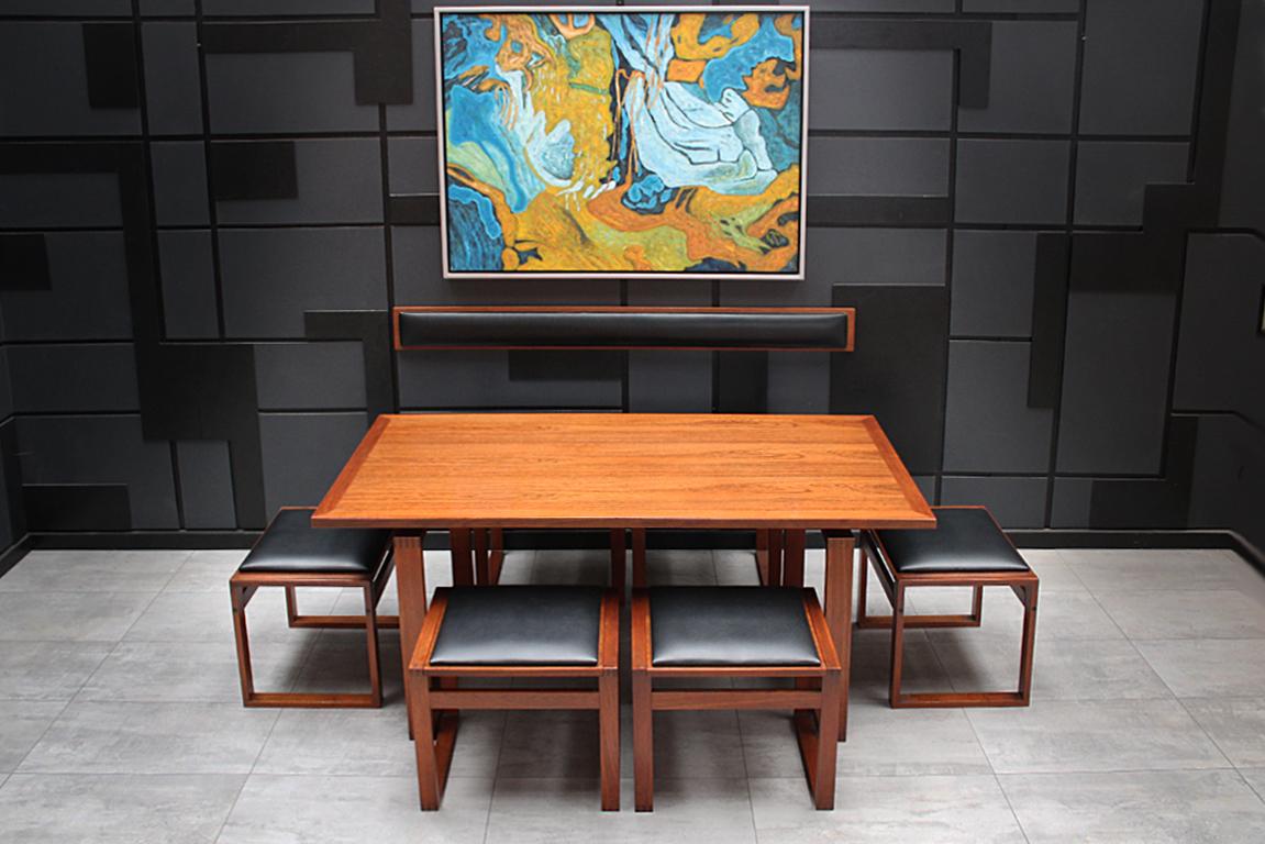 A very rare lounge dining set by Danish midcentury designer Erik Buch. This set features a low lounge dining table with 6 reversible stools and a backrest, and as such is perfect as a space saving dining set for a small dining area. The stool tops