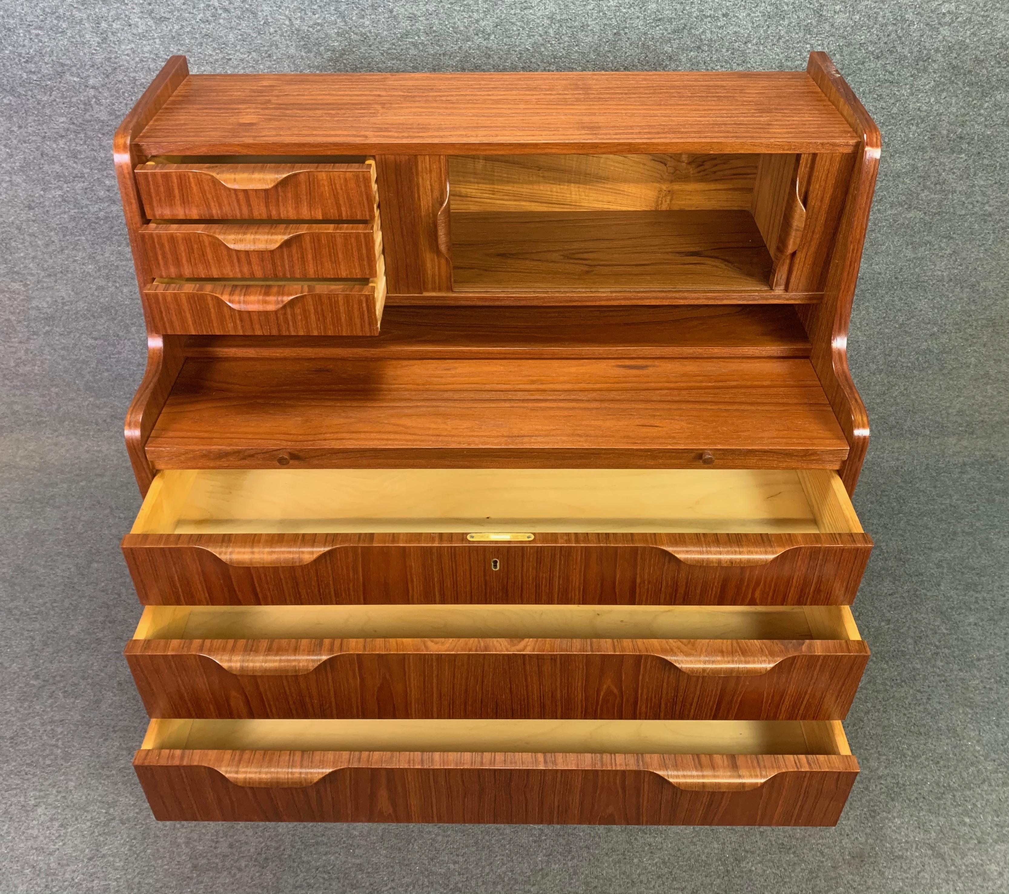 Here is a beautiful 1960s Scandinavian Modern secretary desk in teak reminiscent of Johannes Andersen's design for Uldum Mobelfabrik.
This exquisite case piece, recently imported from Denmark to California before its restoration, features at its