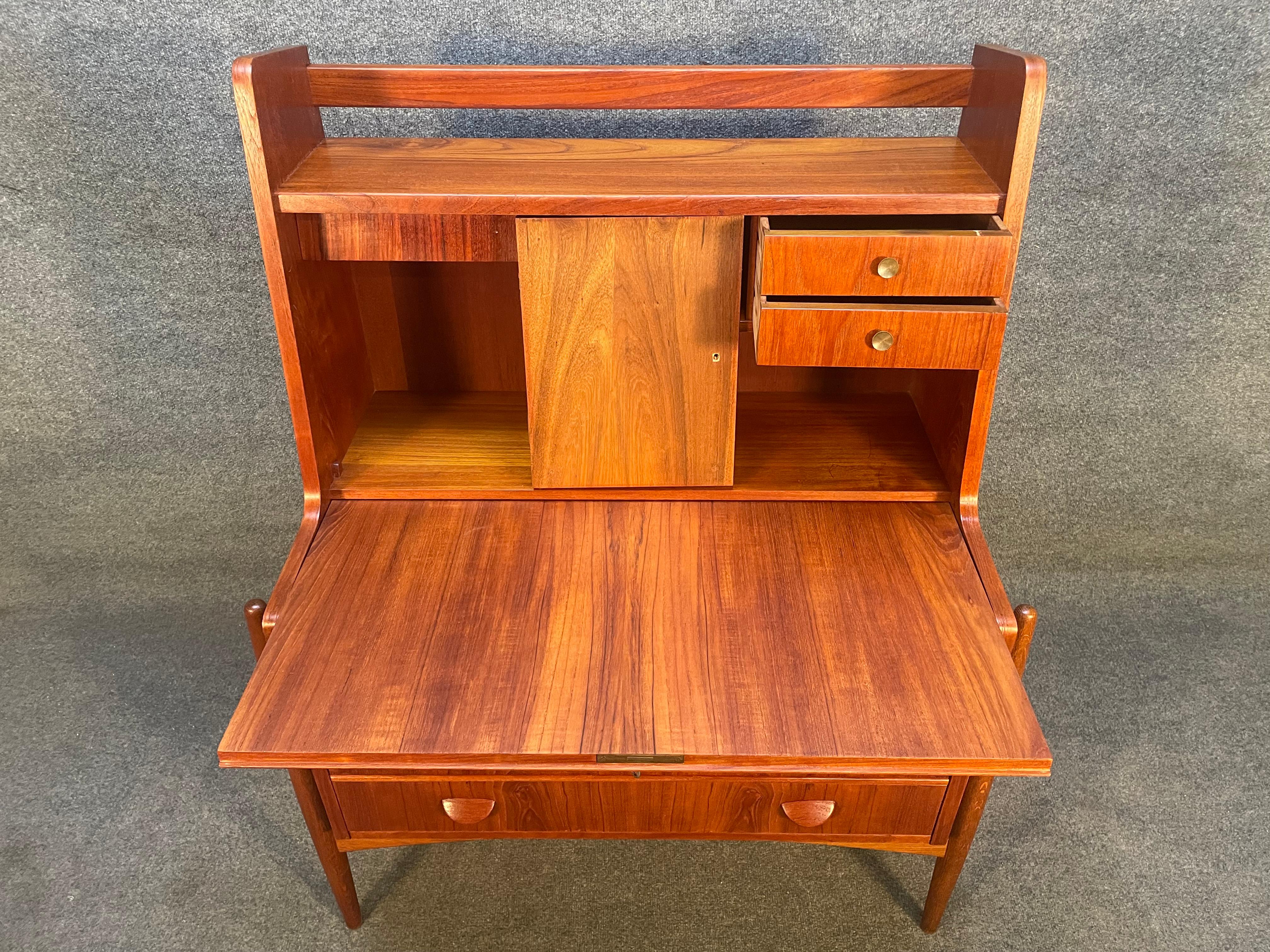 Here is terrific and rare Scandinavian Modern secretary desk in teak wood reminiscent of Johannes Andersen's design.
This special piece, recently imported from Europe to Copenhagen before its refinishing, features a vibrant wood grain, a drop down