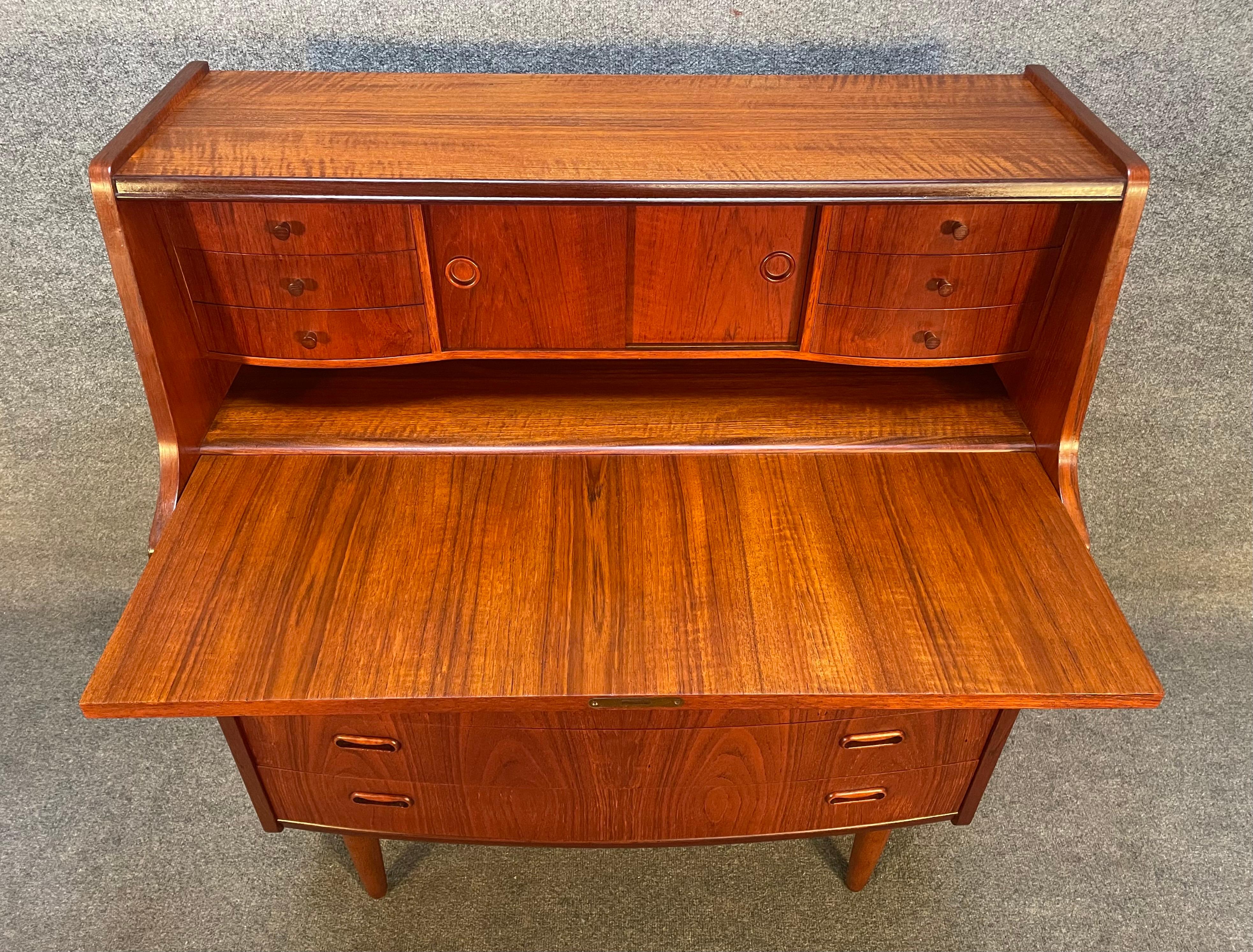 Here is a beautiful scandinavian modern secretary desk in teak wood manufactured by Poul Jessen Mobelfabrik in Denmark in the 1960s.
This lovely versatile piece, recently imported from Europe to California before its refinishing, features a vibrant