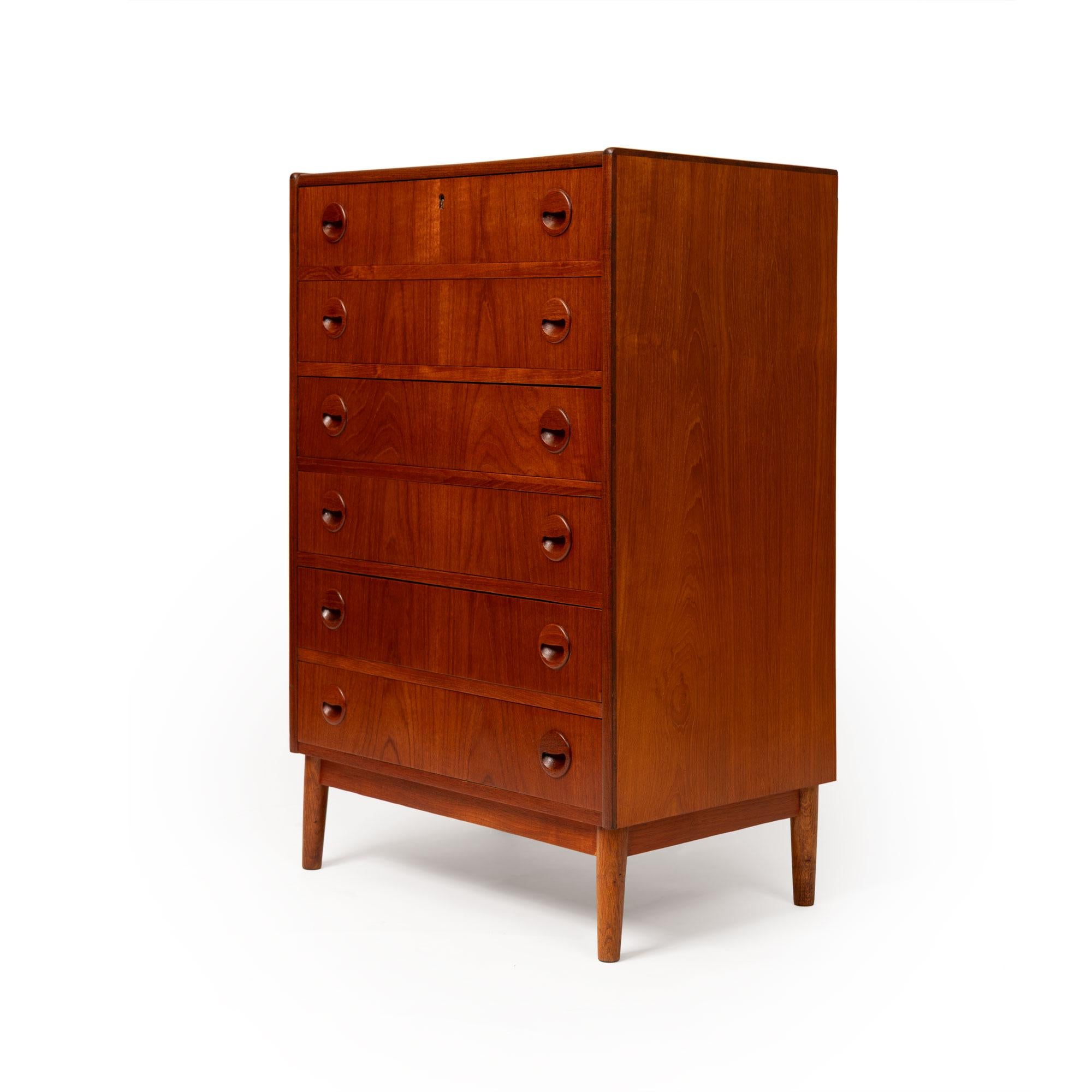 A masterful example of Danish Mid-Century Modern design, this 1960s teak tallboy dresser embodies the harmony of form, function, and fine craftsmanship that defined the era. Expertly constructed from richly grained teak, the piece showcases the