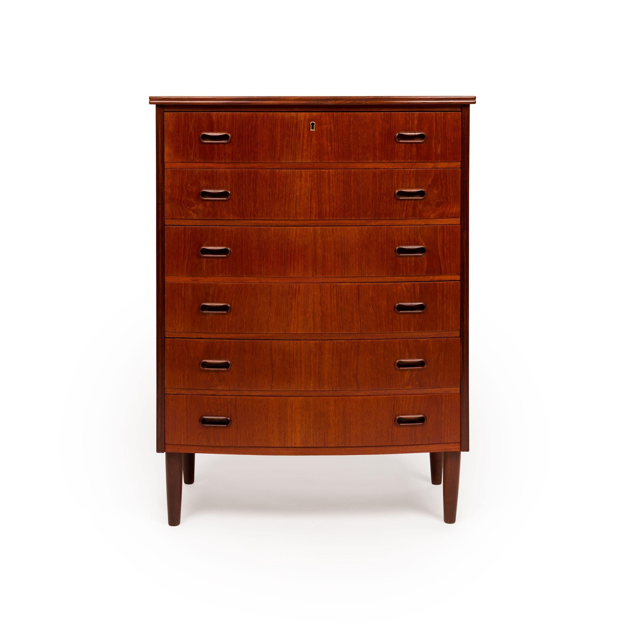 A masterful example of Danish Mid-Century Modern design, this 1960s teak tallboy dresser embodies the harmony of form, function, and fine craftsmanship that defined the era. Expertly constructed from richly grained teak, the piece showcases the