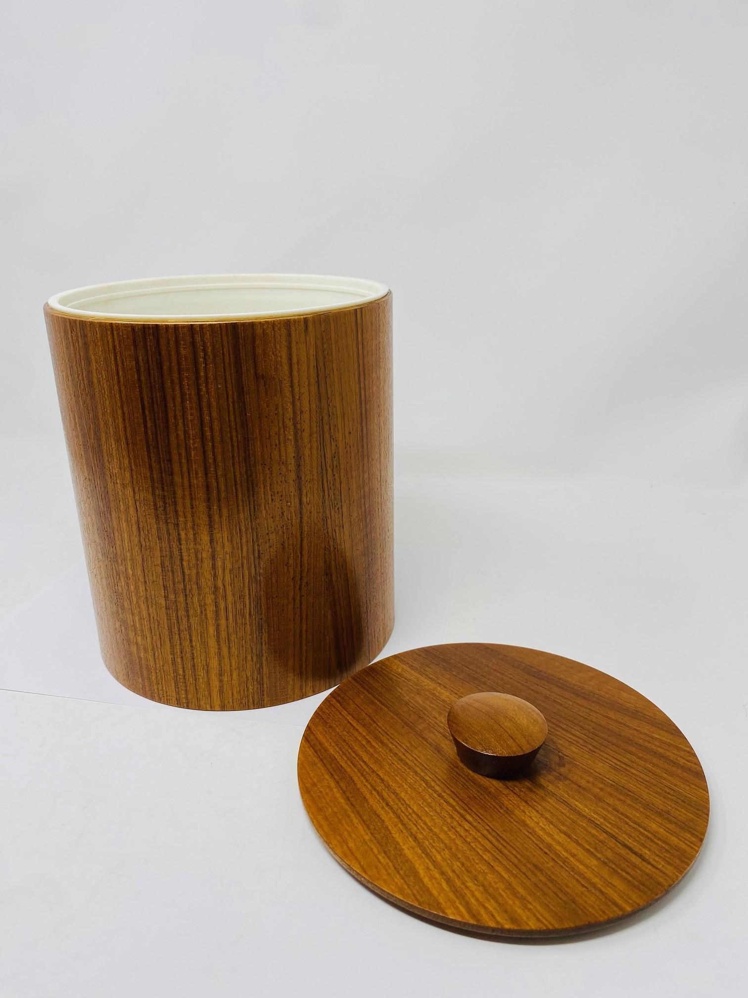 Unique and beautifully crafted vintage Danish midcentury teak ice bucket. This piece has minimal, clean lines while enveloped in the grain of teak with plastic insert.  Linear in shape but rich in style.

Mid-Century, Hollywood Regency, Art Deco,