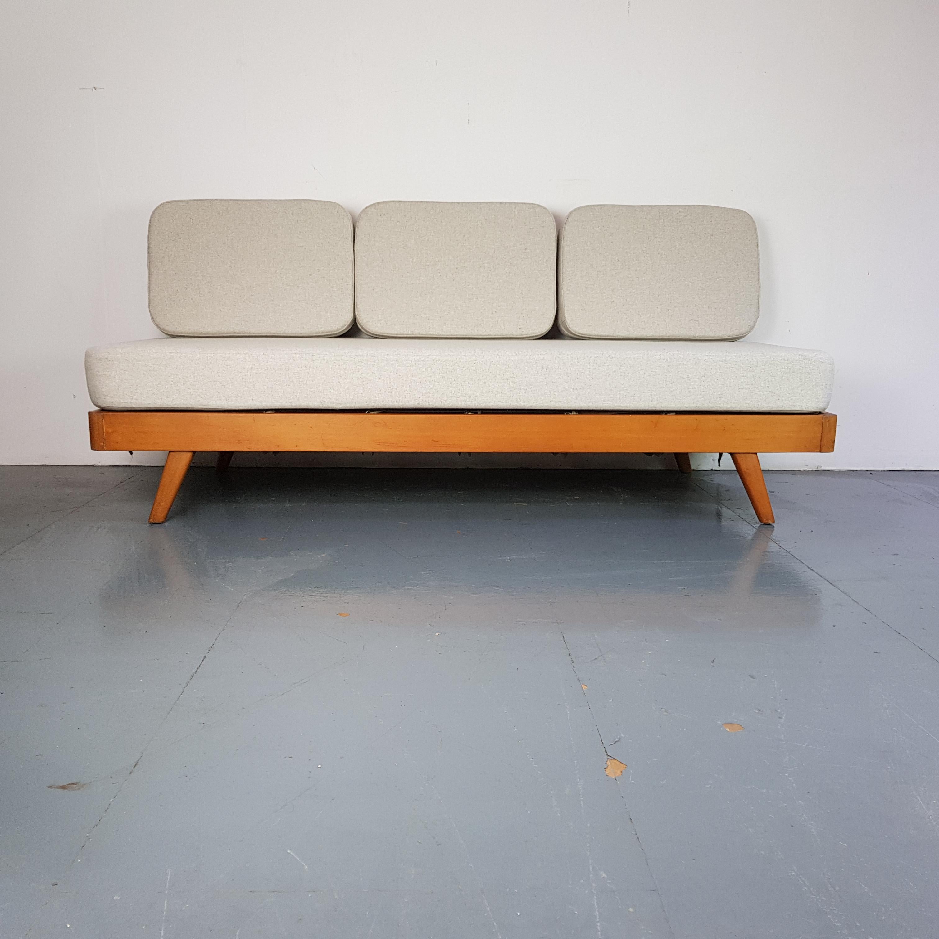 Vintage Danish 1960s daybed.

In very good vintage condition.

The cushions have been reupholstered in a light grey fabric. They are removable and the back can be folded down to create a sofa bed. 

The foam cushion pads are all new as well