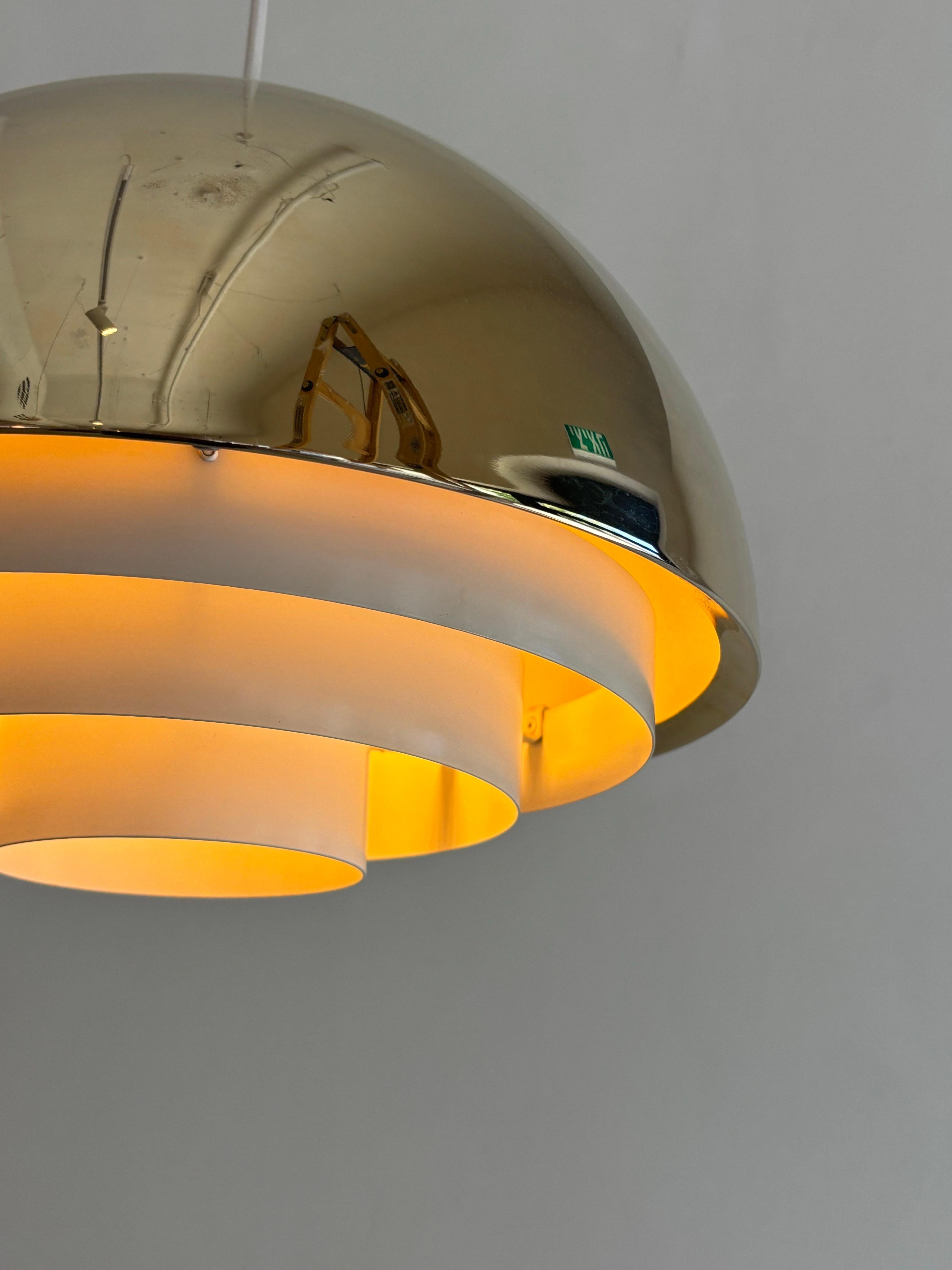 The Milieu lamp from the Golden Line is a striking vintage piece designed in the 1970s by the celebrated Danish designer Jo Hammerborg and produced by Fog & Mørup. A testament to Hammerborg’s refined approach to modernist lighting, the lamp is