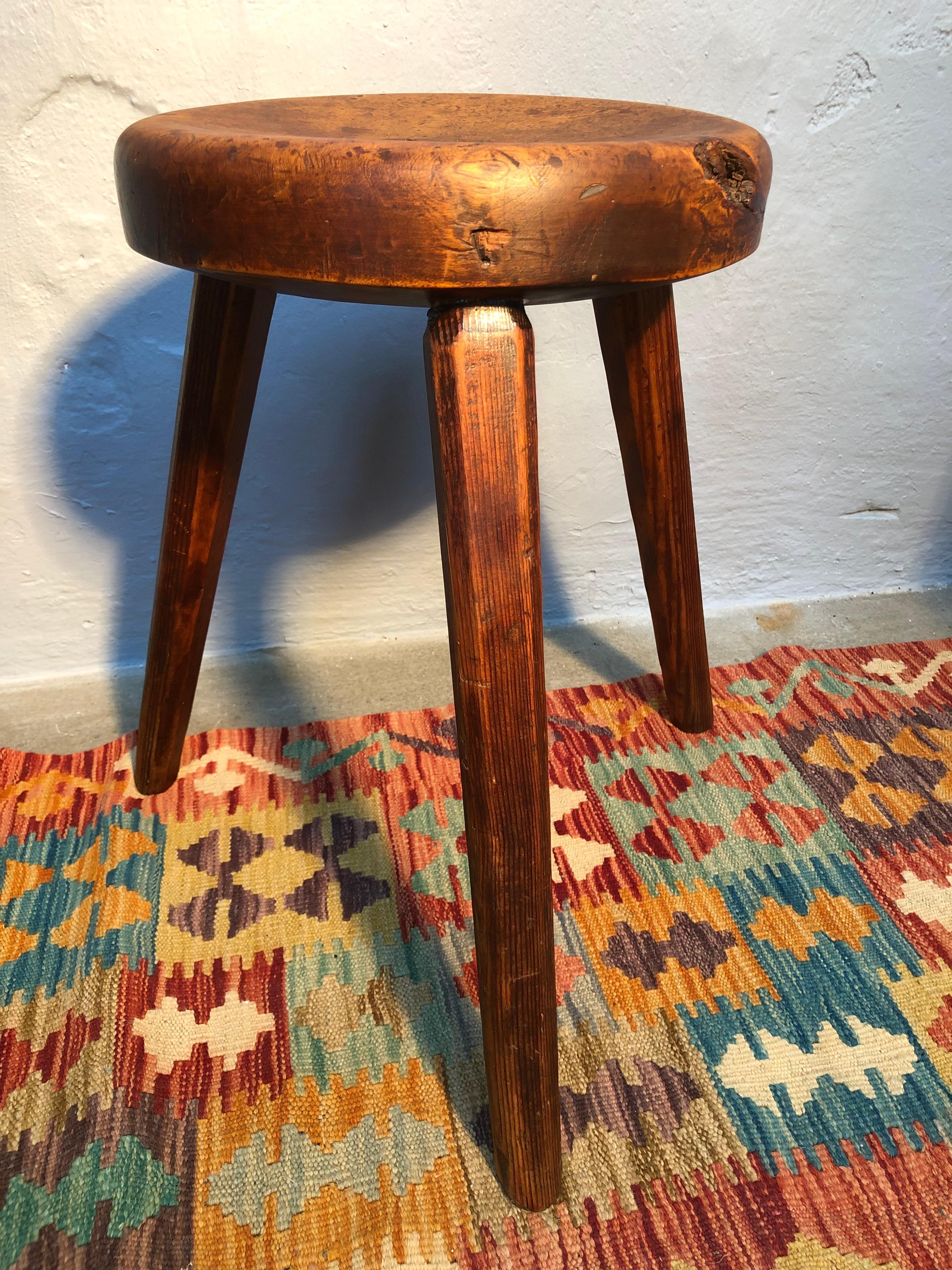 A vintage Danish milking stool dated 1939 on the base in pinewood. 
The seat is turned pinewood with a good thickness of 6 centimeters. 
The legs are planed pinewood. 
A very simplistic beautifully made artisan design. 
The most gorgeous patina