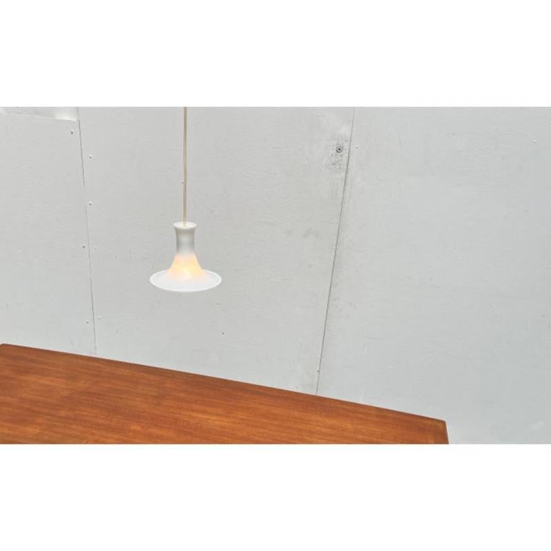 Elegant glass pendant lamp from the Danish manufacturer Holmegaard based on a design by Michael Bang from the 70s.

A design in traditional design language. This pendant light impresses with its elegant curves. The opal glass is clear at the bottom